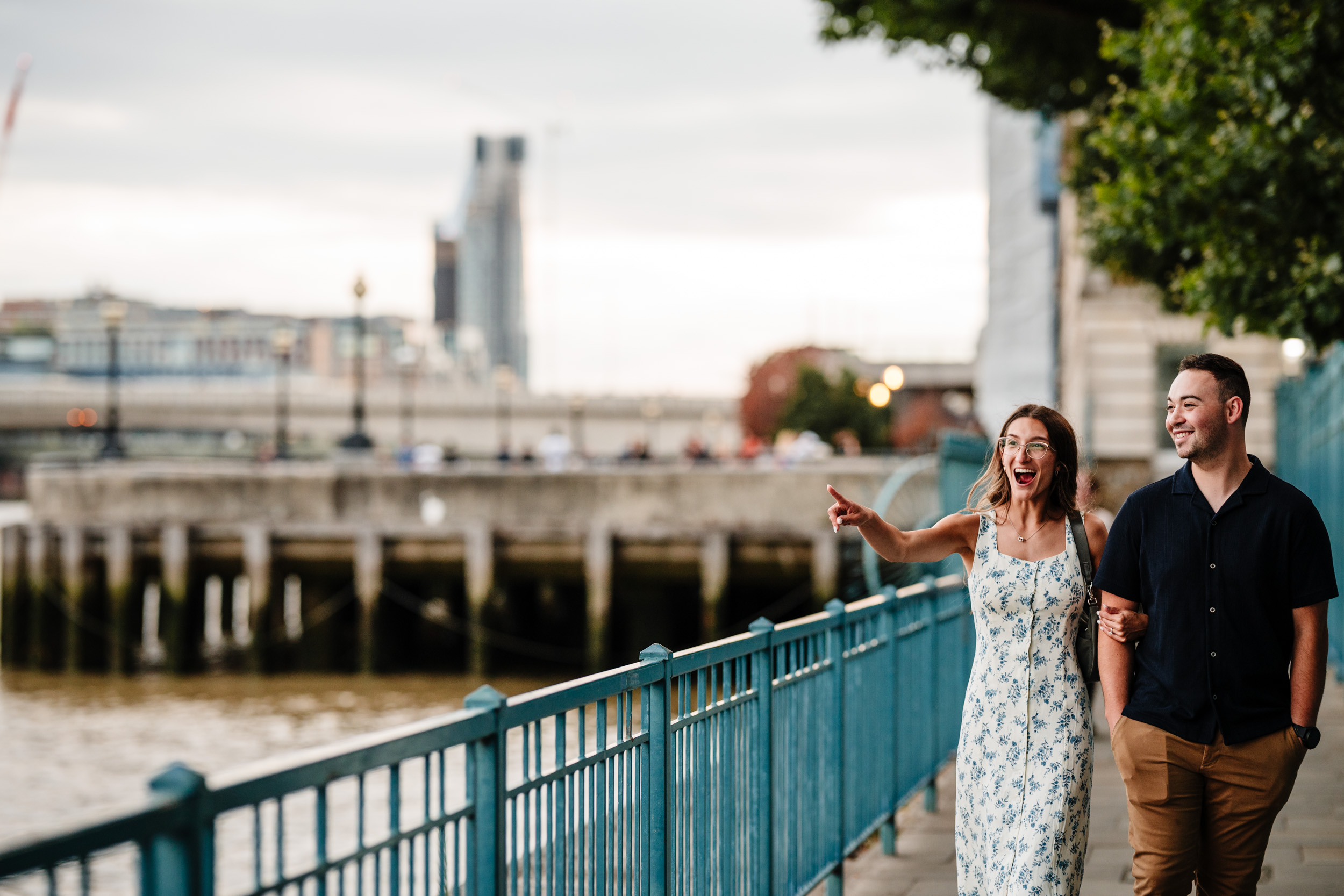 couple laughing pointing at Tower Bridge