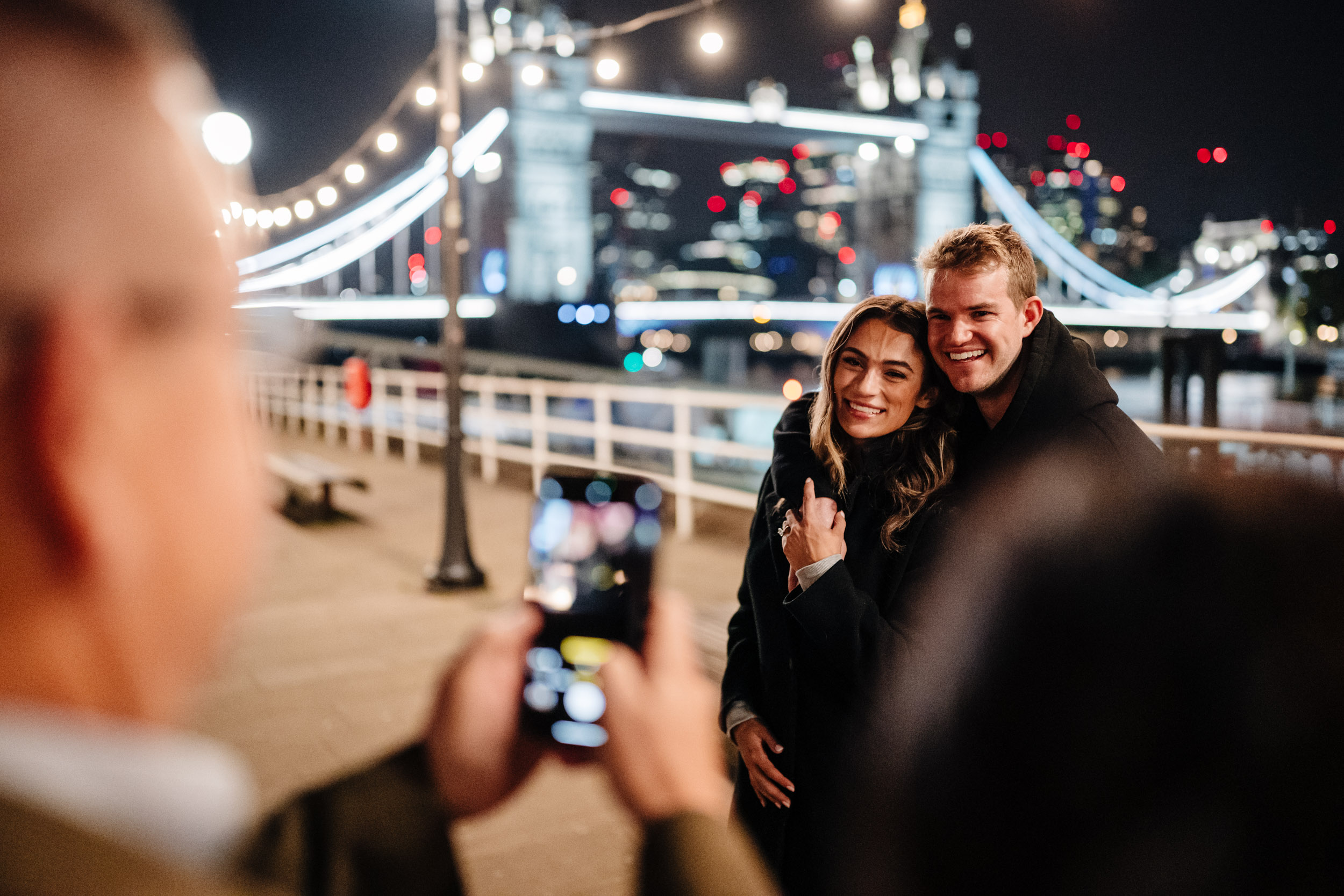 couple being photographed right after they got engaged at Tower Bridge
