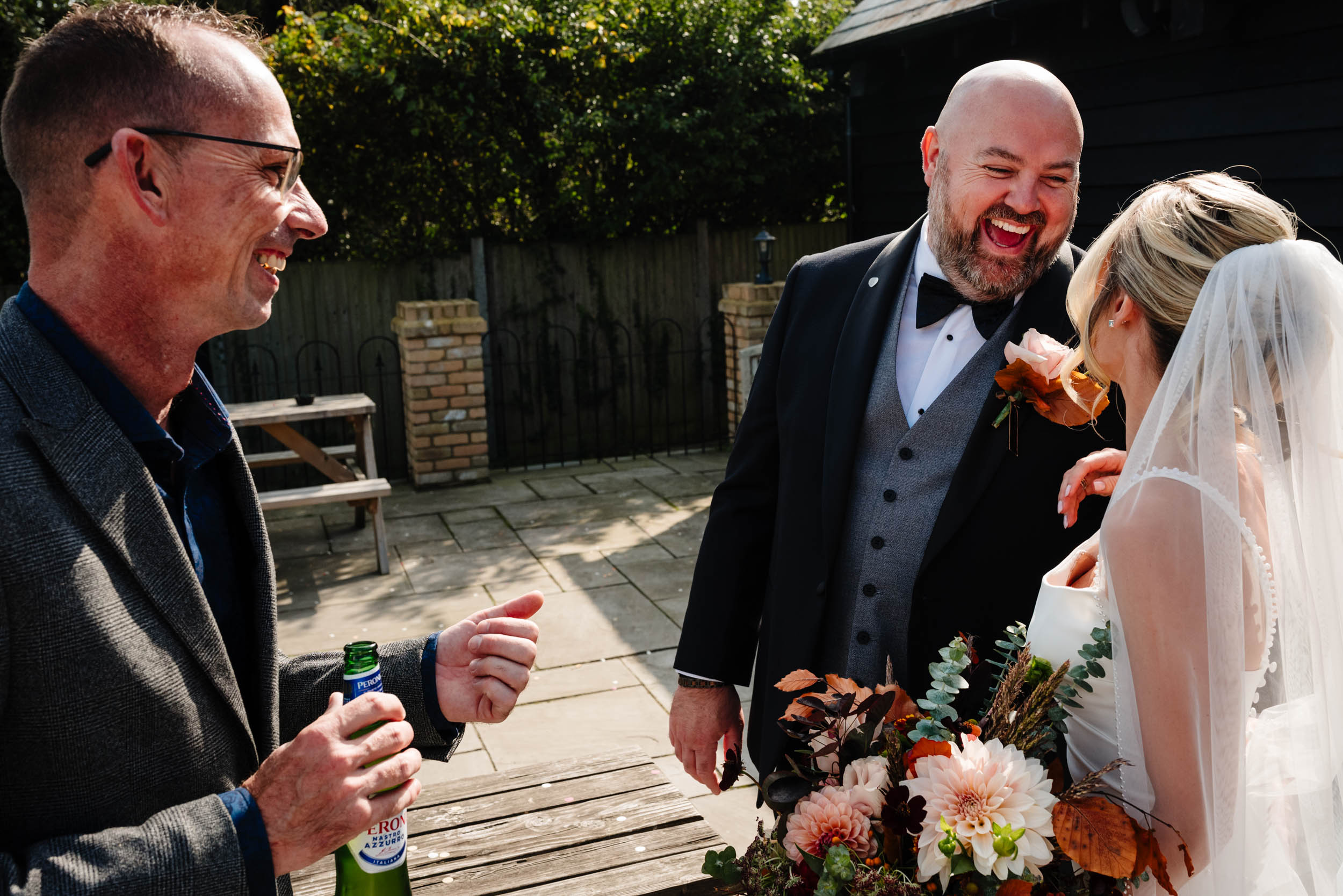 bride groom and groom's brother laughing
