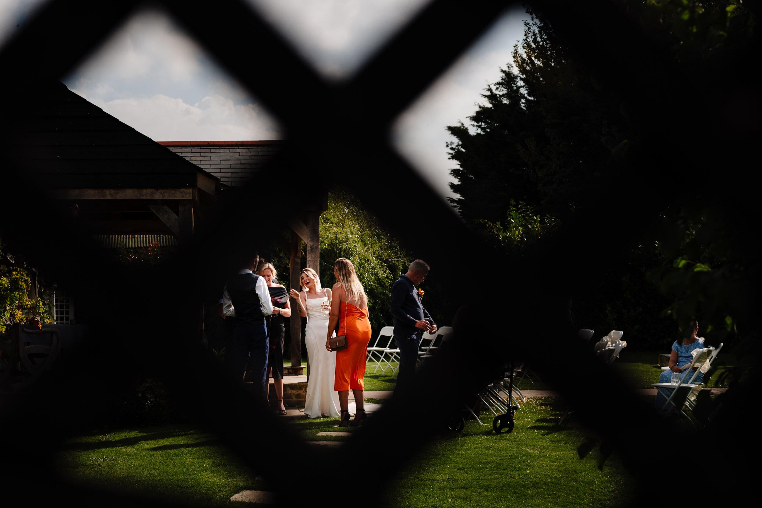 bride laughing view through fence