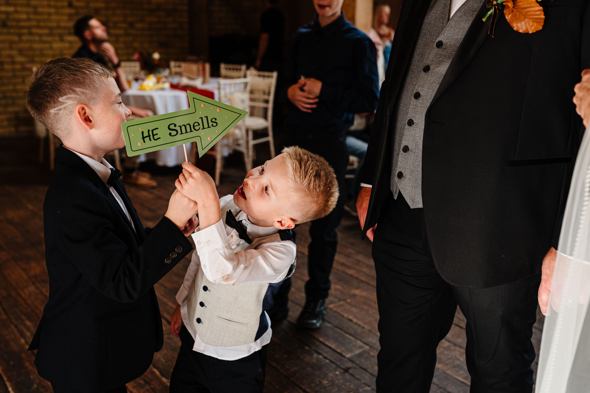 kids holding a he smells sign
