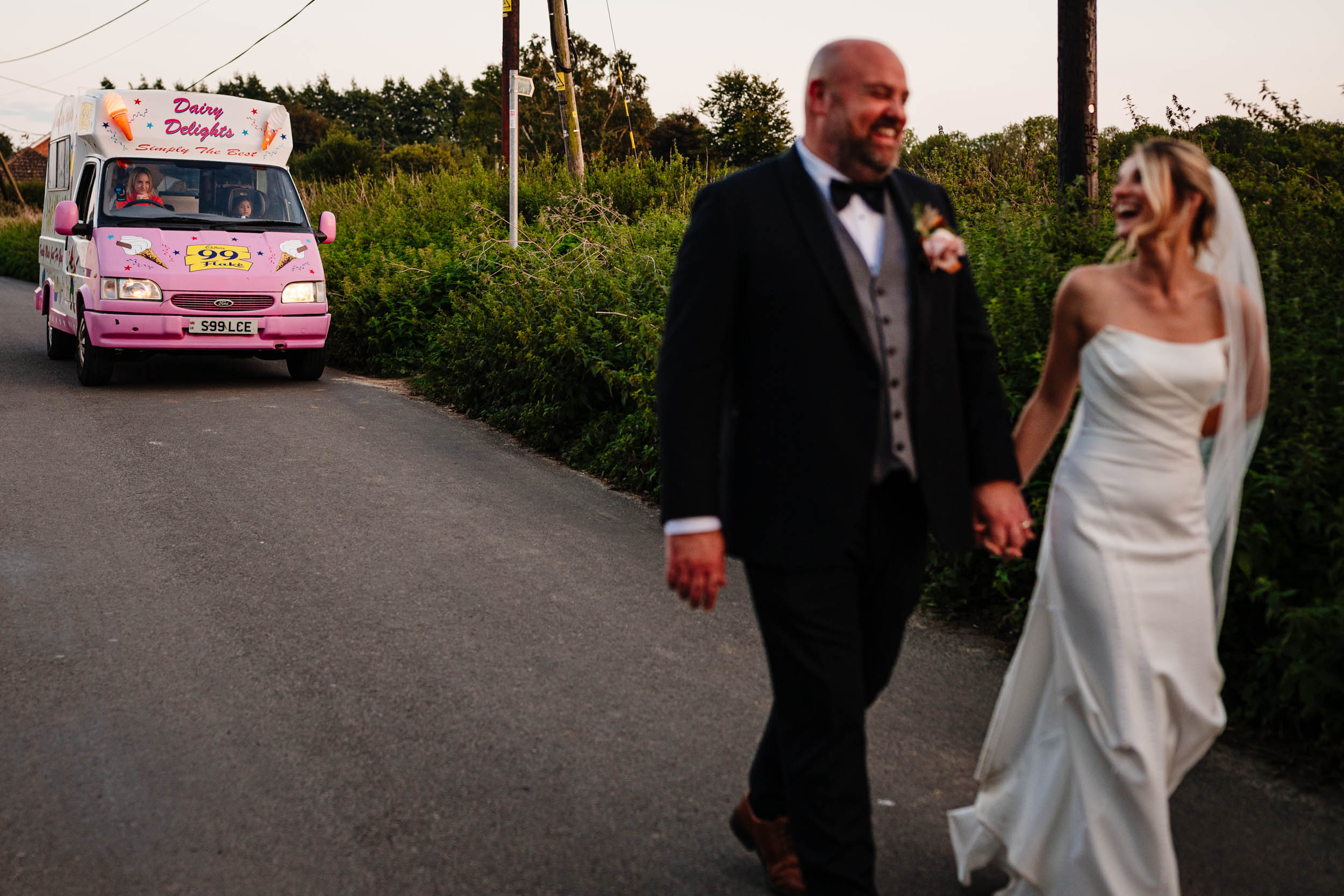 bride and groom walking towards the venue with the ice cream truck behind them