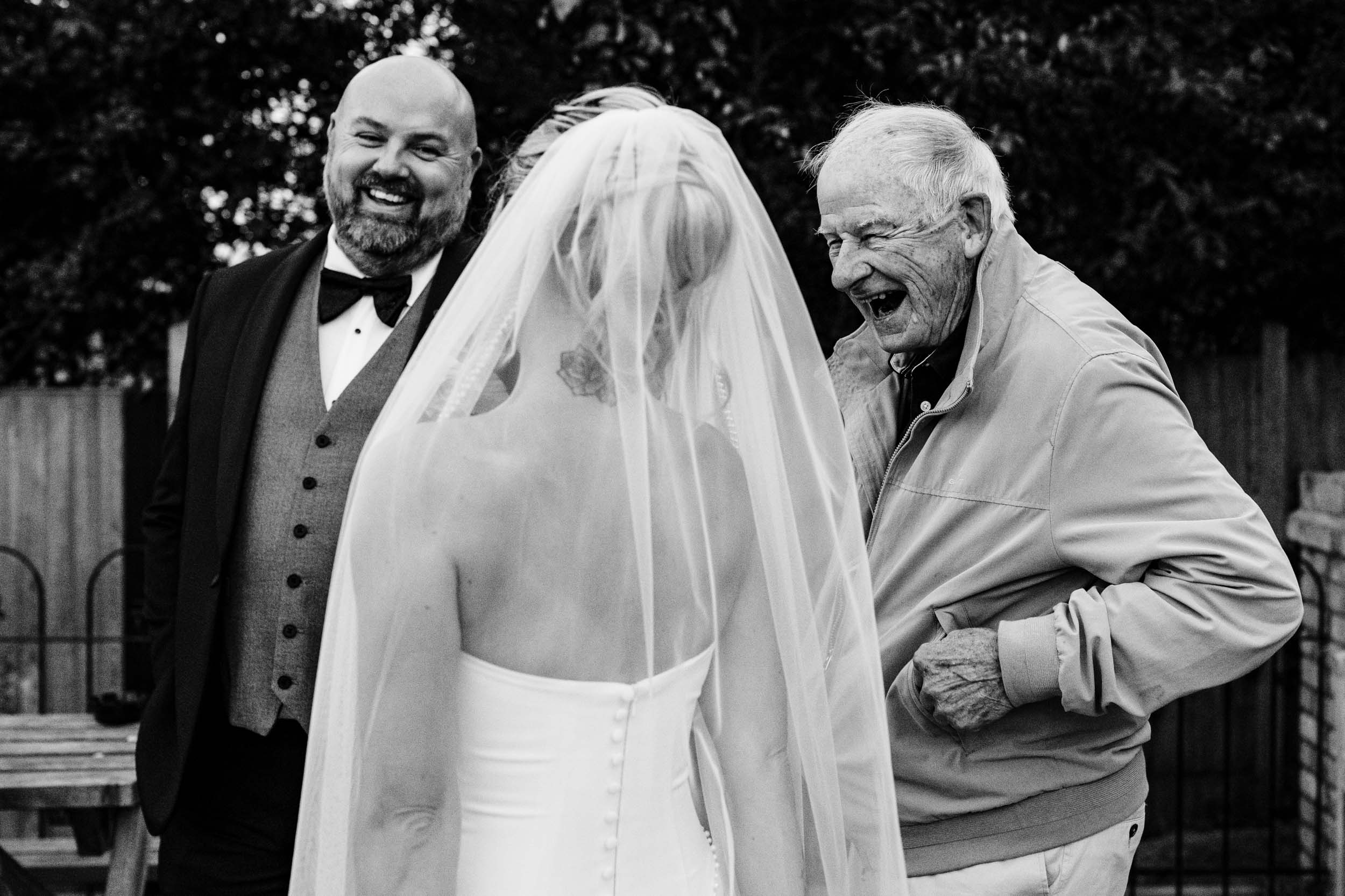 bride and groom happy laugh with an elderly guest