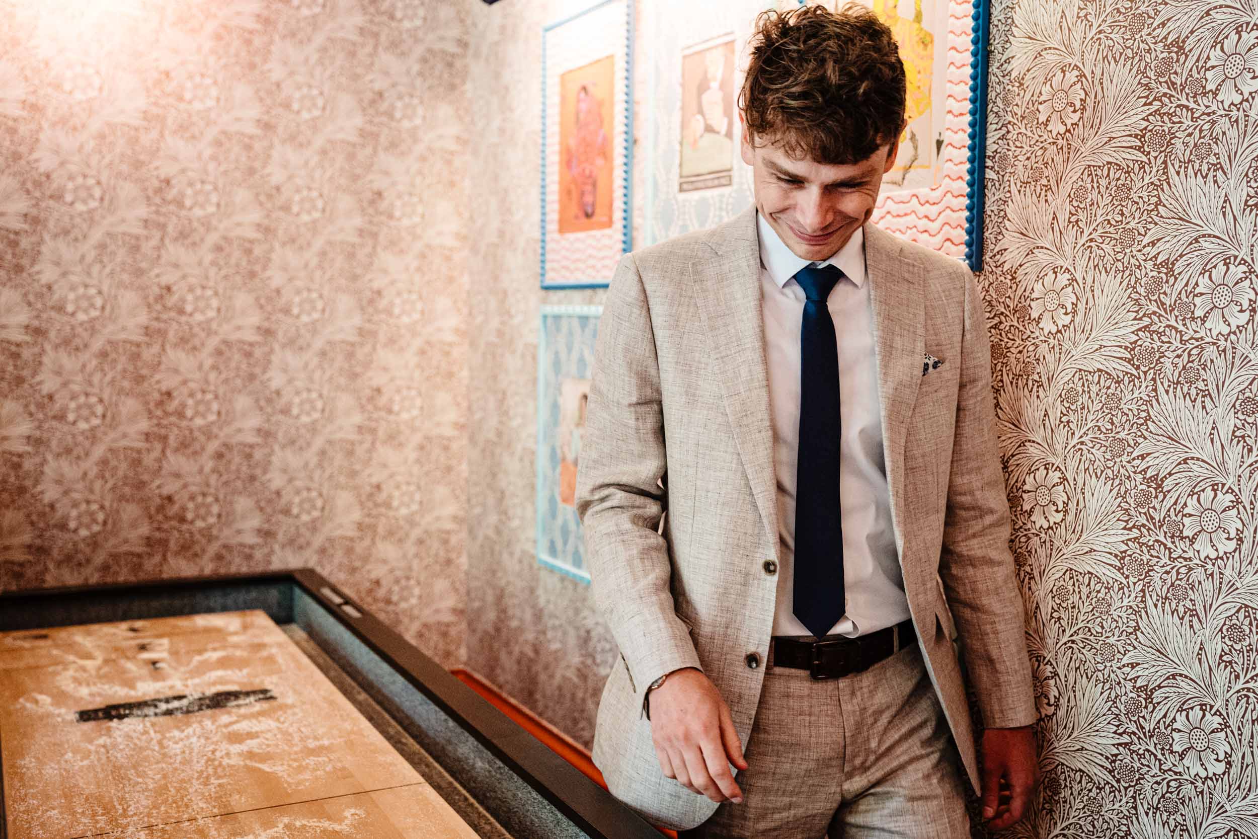 Groomsman walking past the games tables laughing with friends