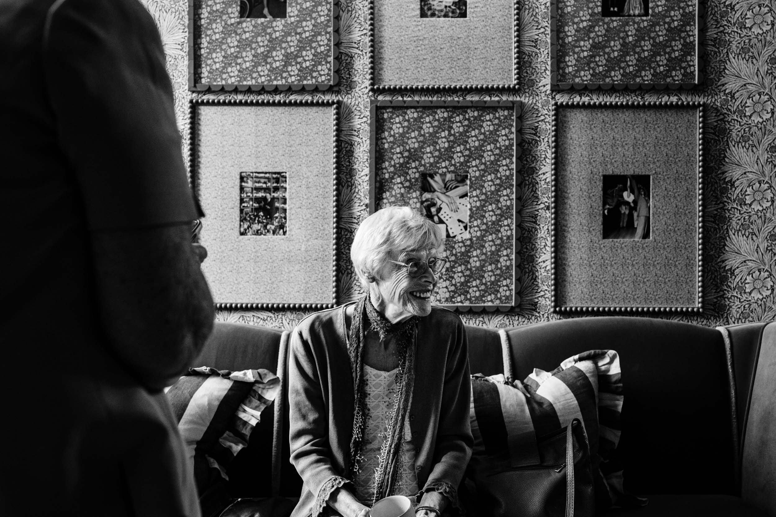 Elderly wedding guest laughing during morning arrivals