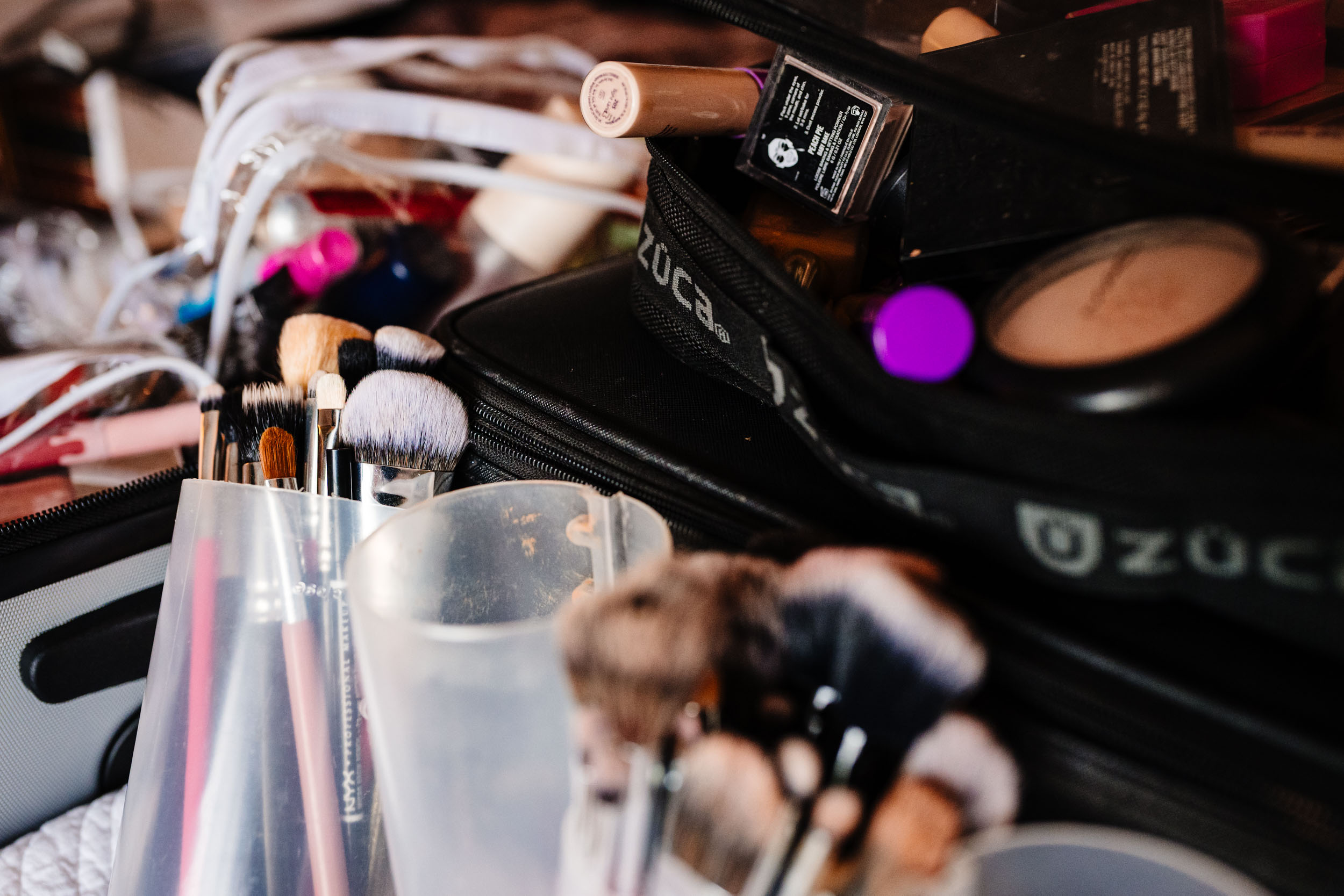 Close up of makeup brushes and products during bridal prep