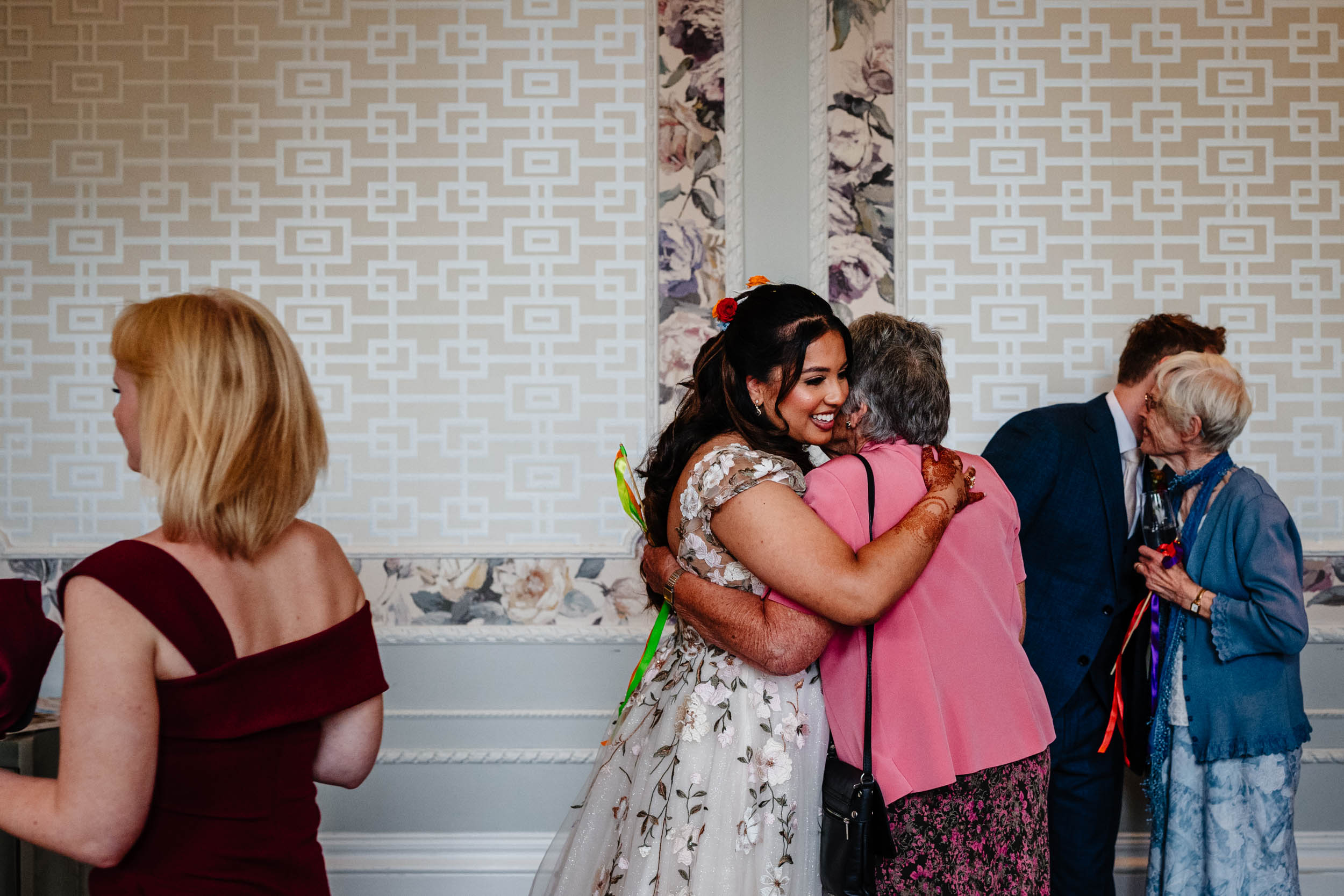 Anika and Sam hugging two elderly ladies during the reception inside Hampton Manor