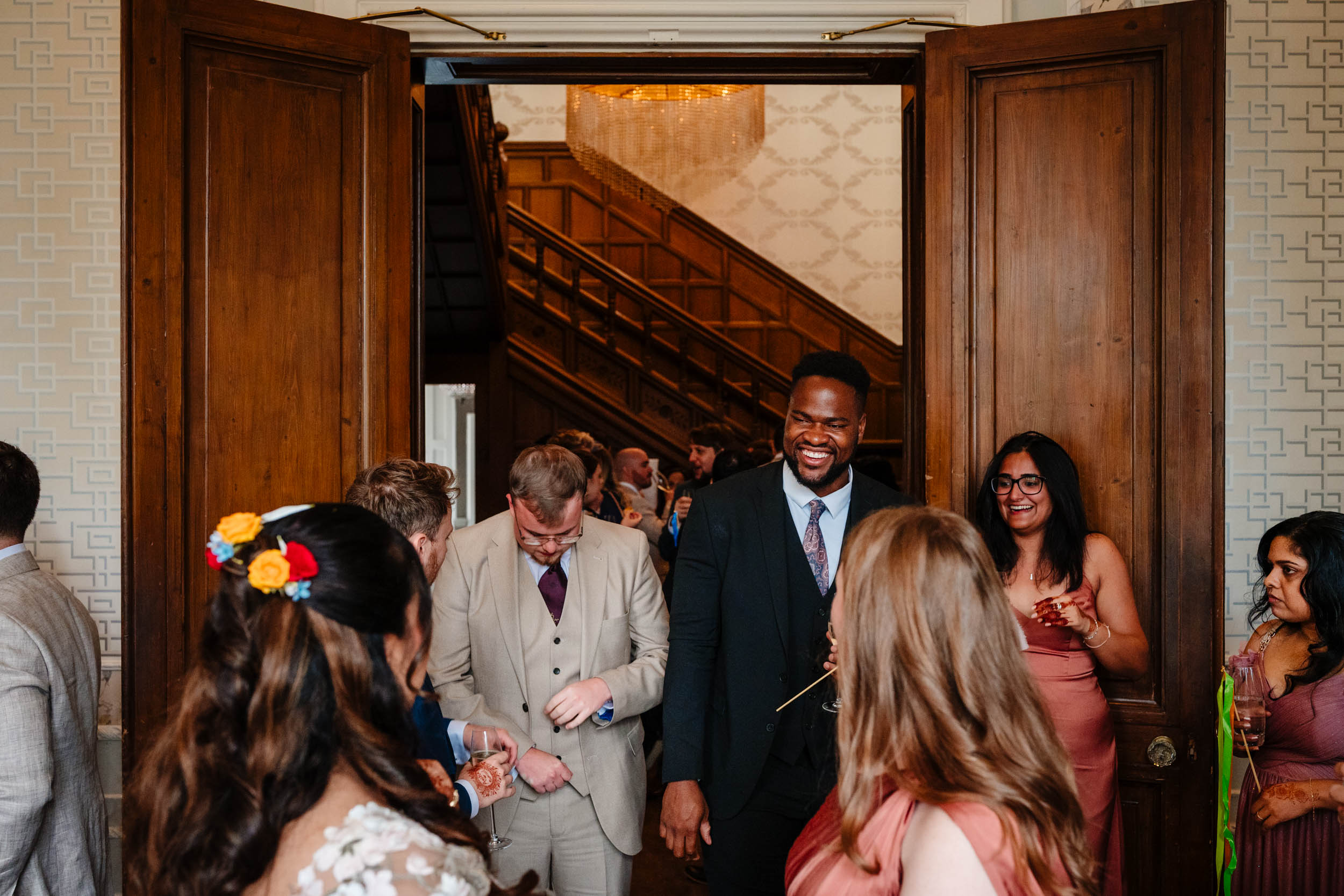 Guests laughing together during the indoor reception at Hampton Manor