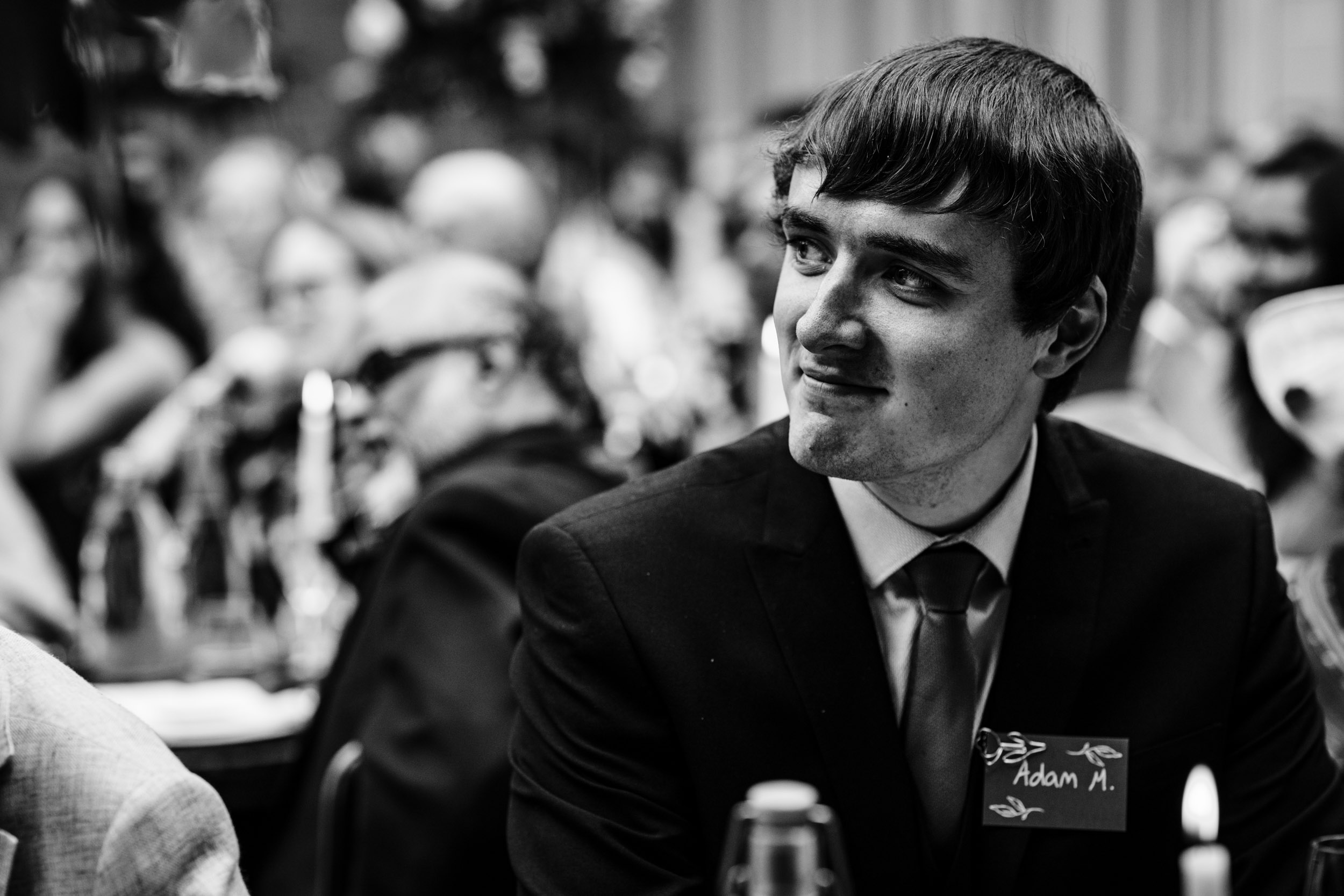 Wedding guest smiling proudly during the speeches