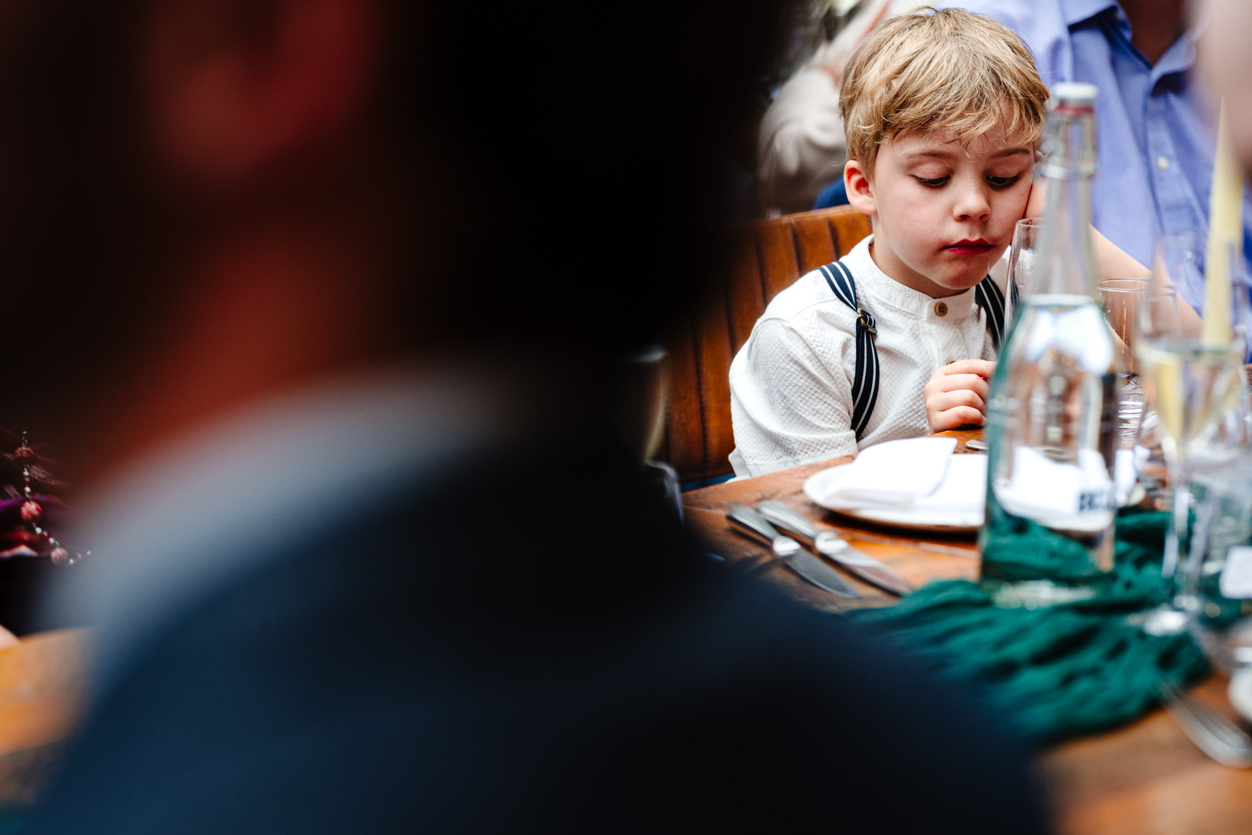 Child looking bored during wedding speeches at Hampton Manor