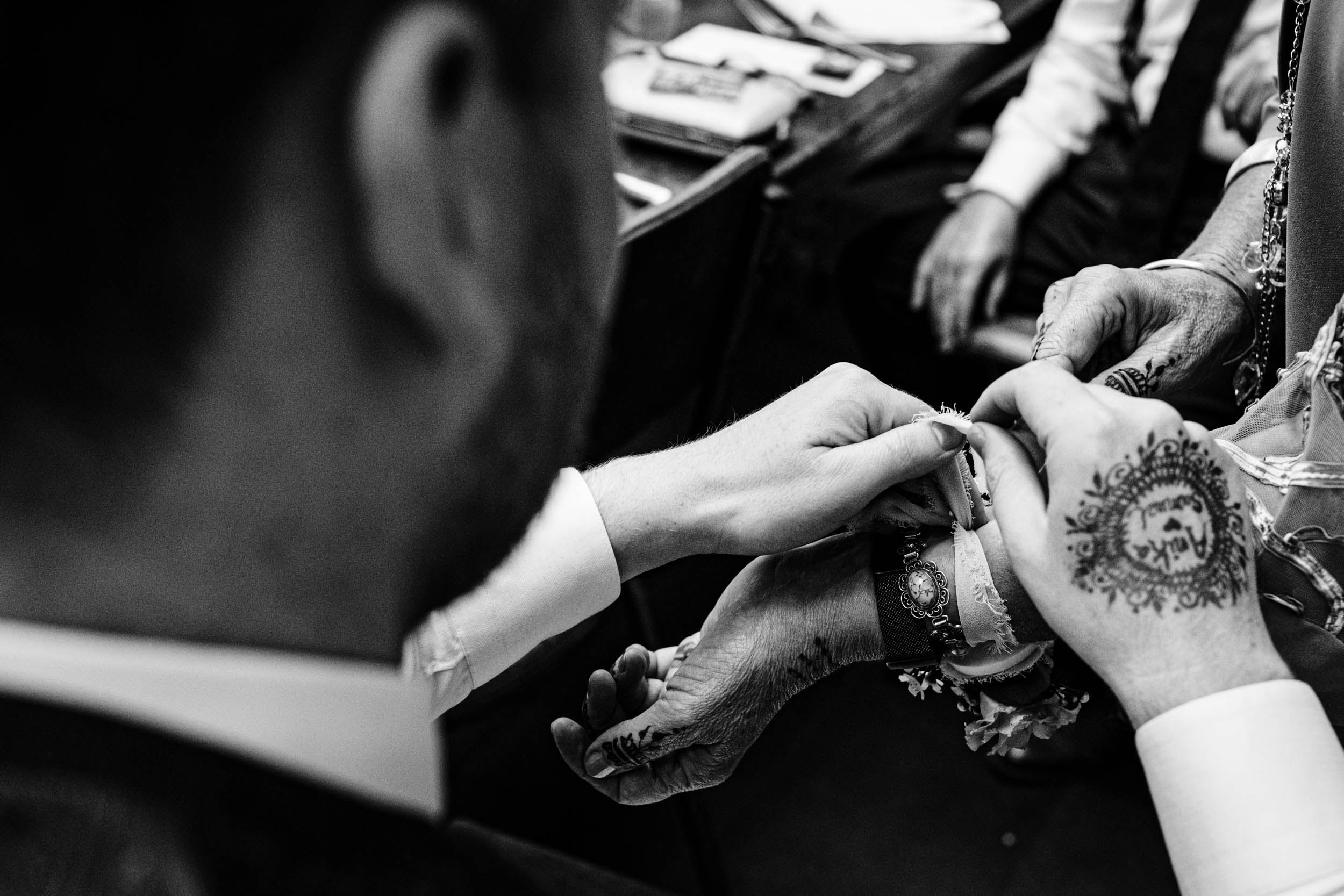 Sam adjusting something on Anika’s hand showing his henna tattoo