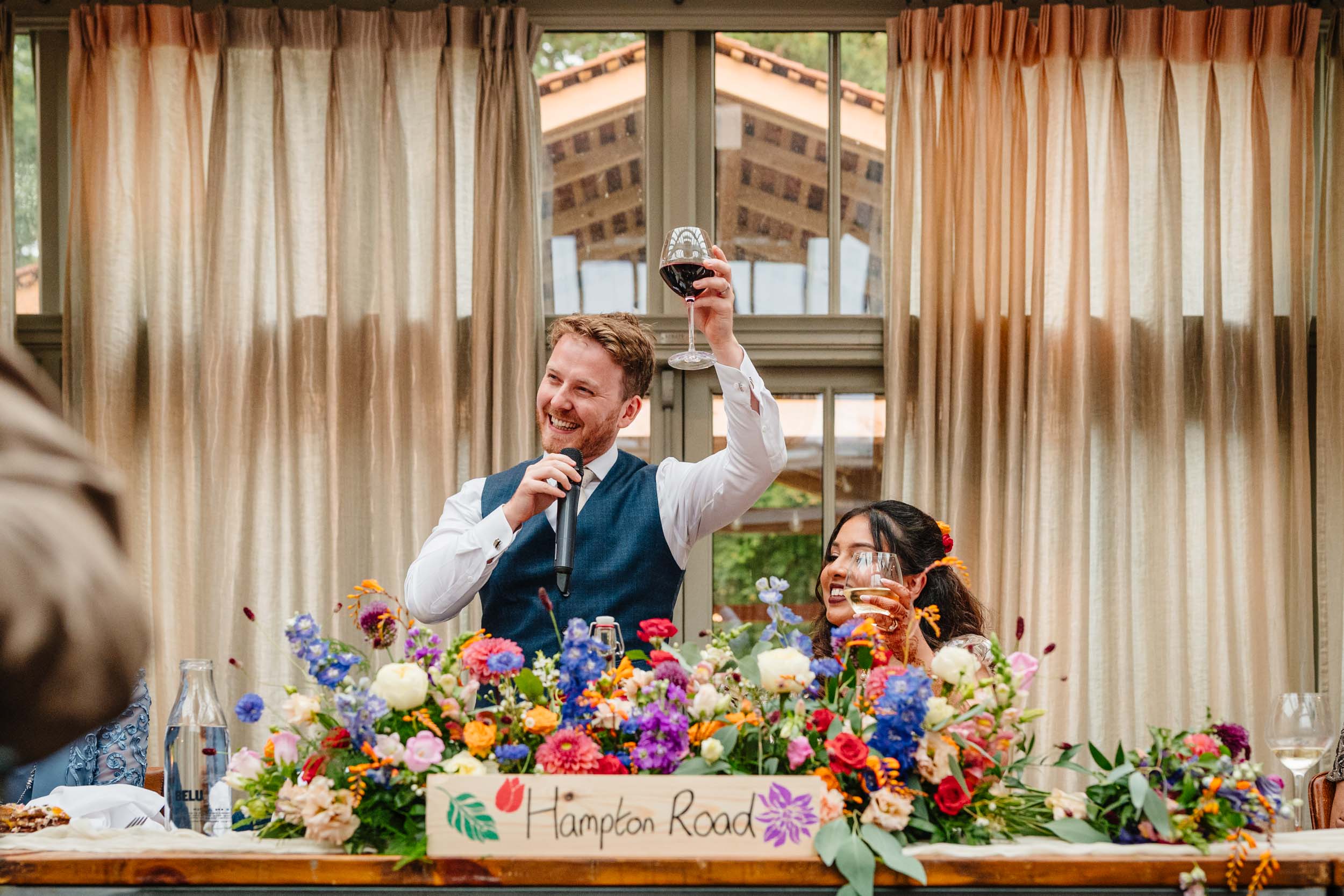 Groom raising a glass during his speech at the top table