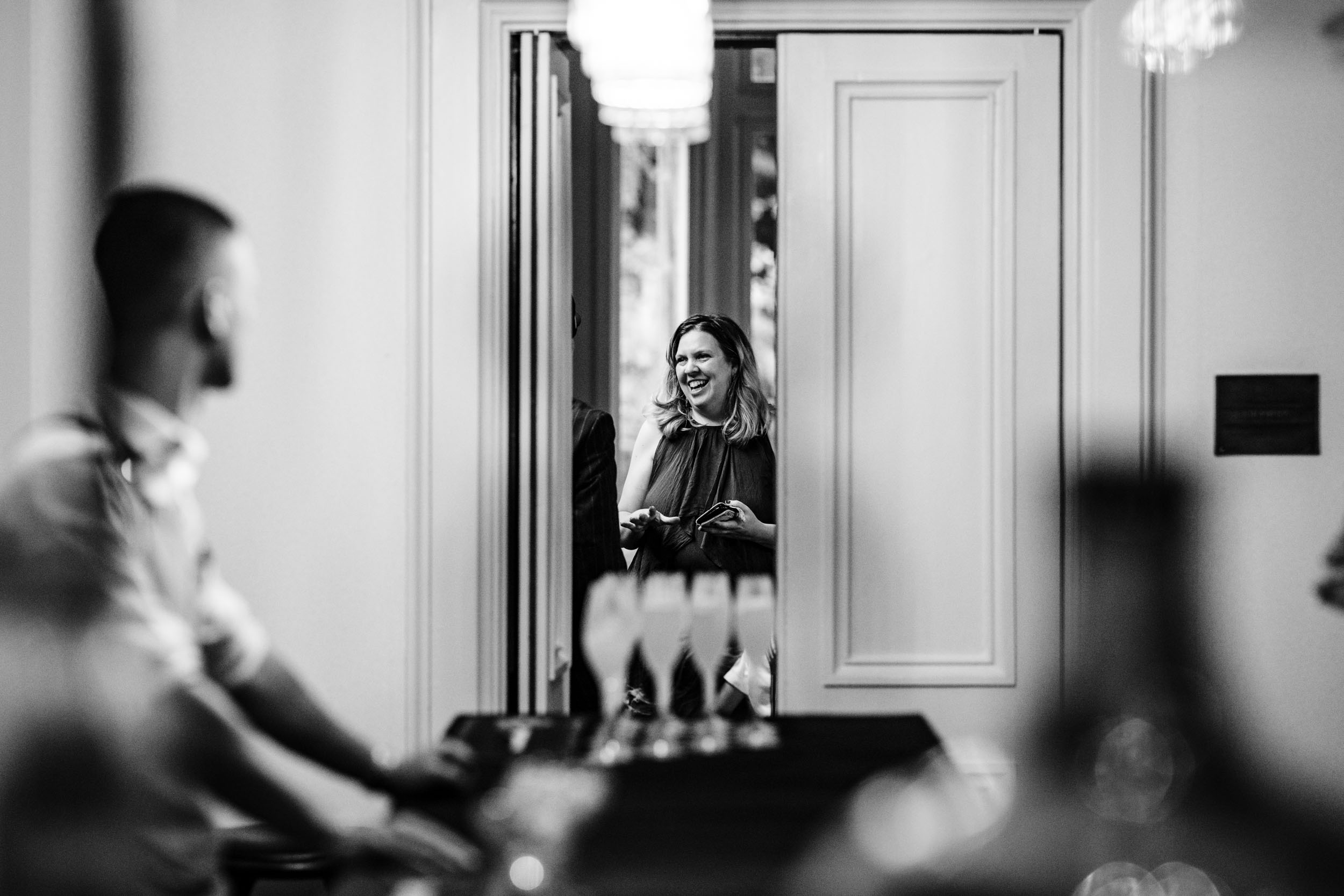 Candid photo of a woman laughing through a doorway
