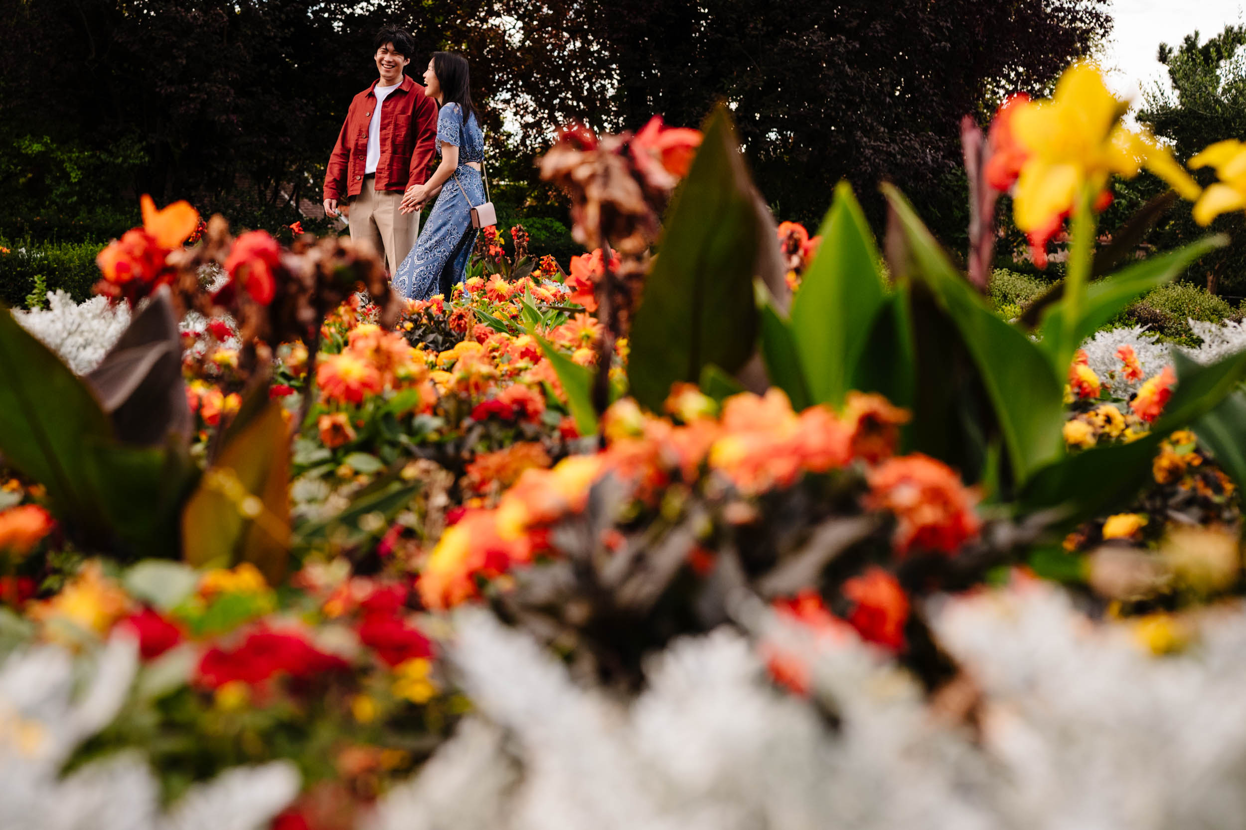 Photo framed with flowers as the couple laugh together at Holland Park