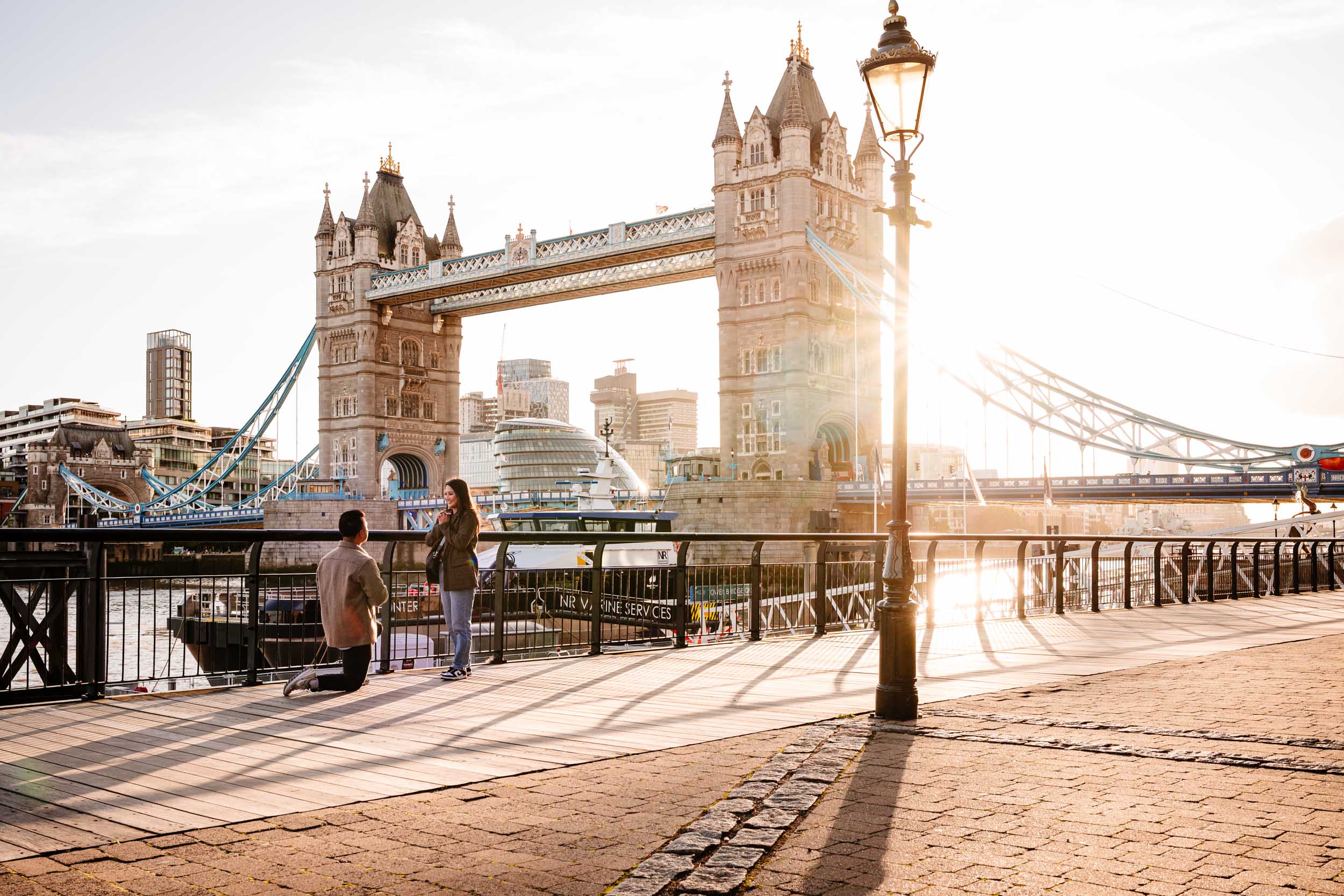 James proposing to Christine at Tower Bridge during sunset in London