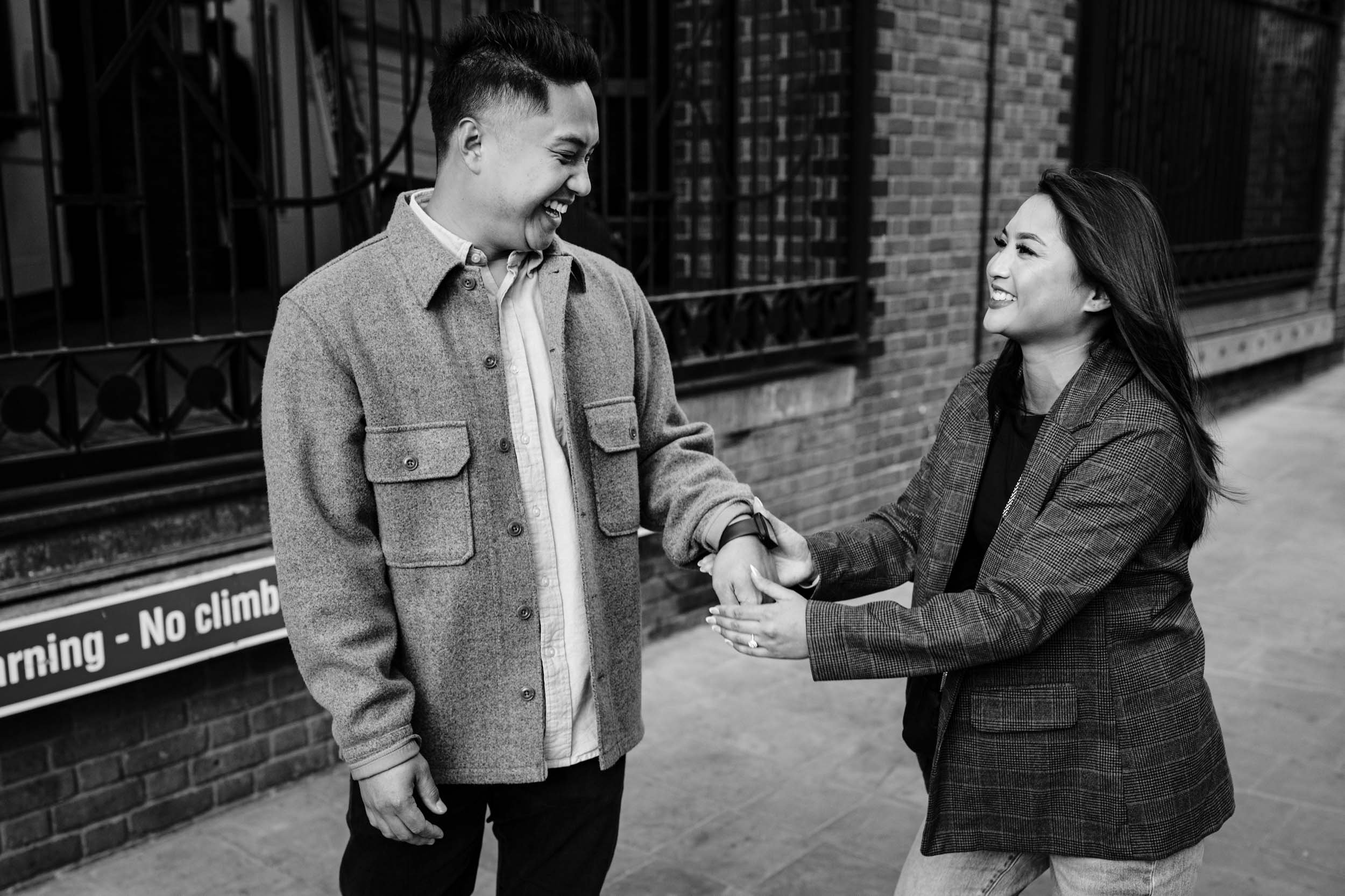 Couple laughing together after the proposal near Tower Bridge