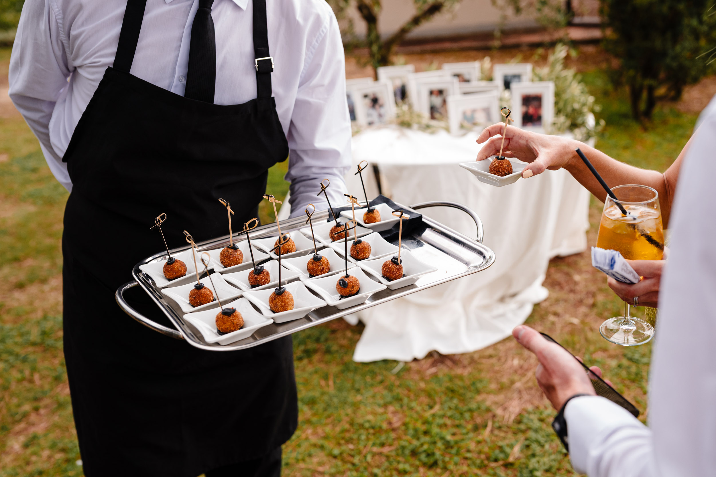 Waiter serving canapés to guests during the outdoor drinks reception.