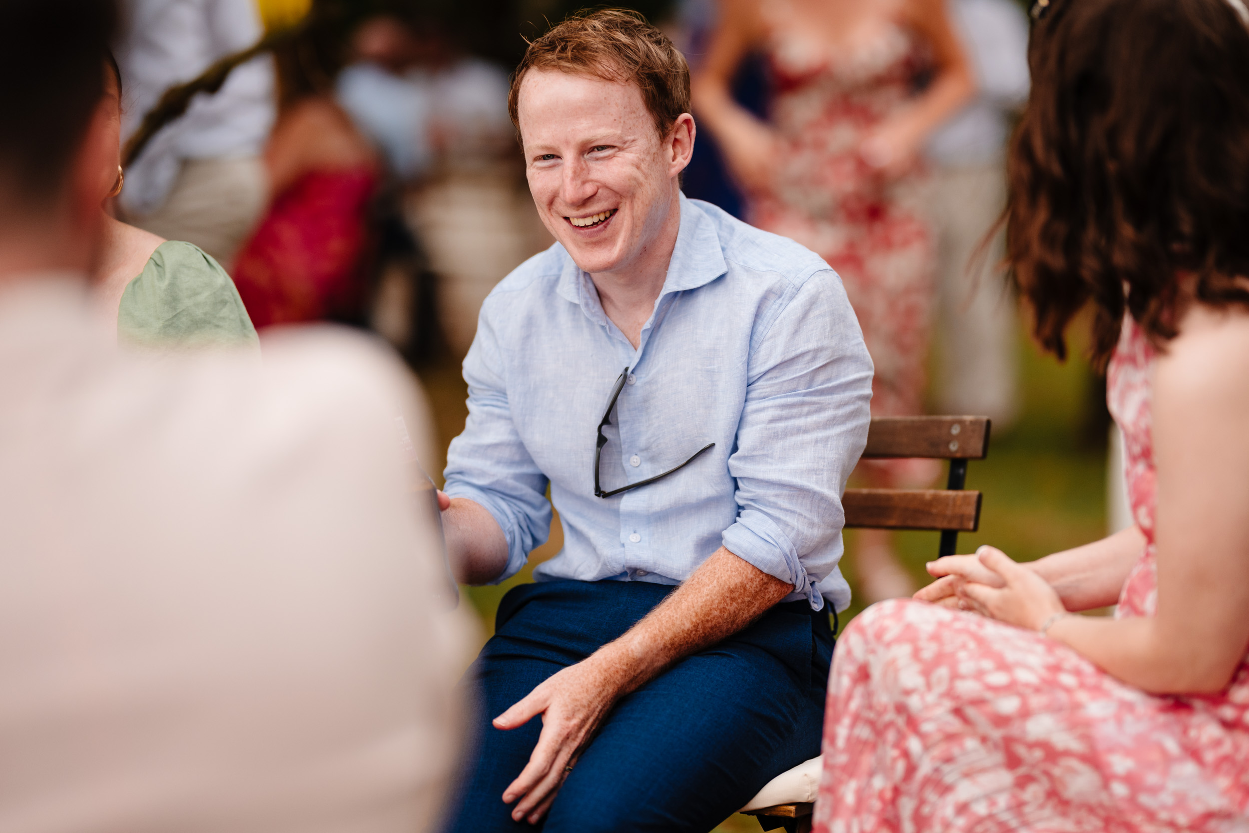 Wedding guest laughing while chatting with friends at Casale de Pasquinelli.