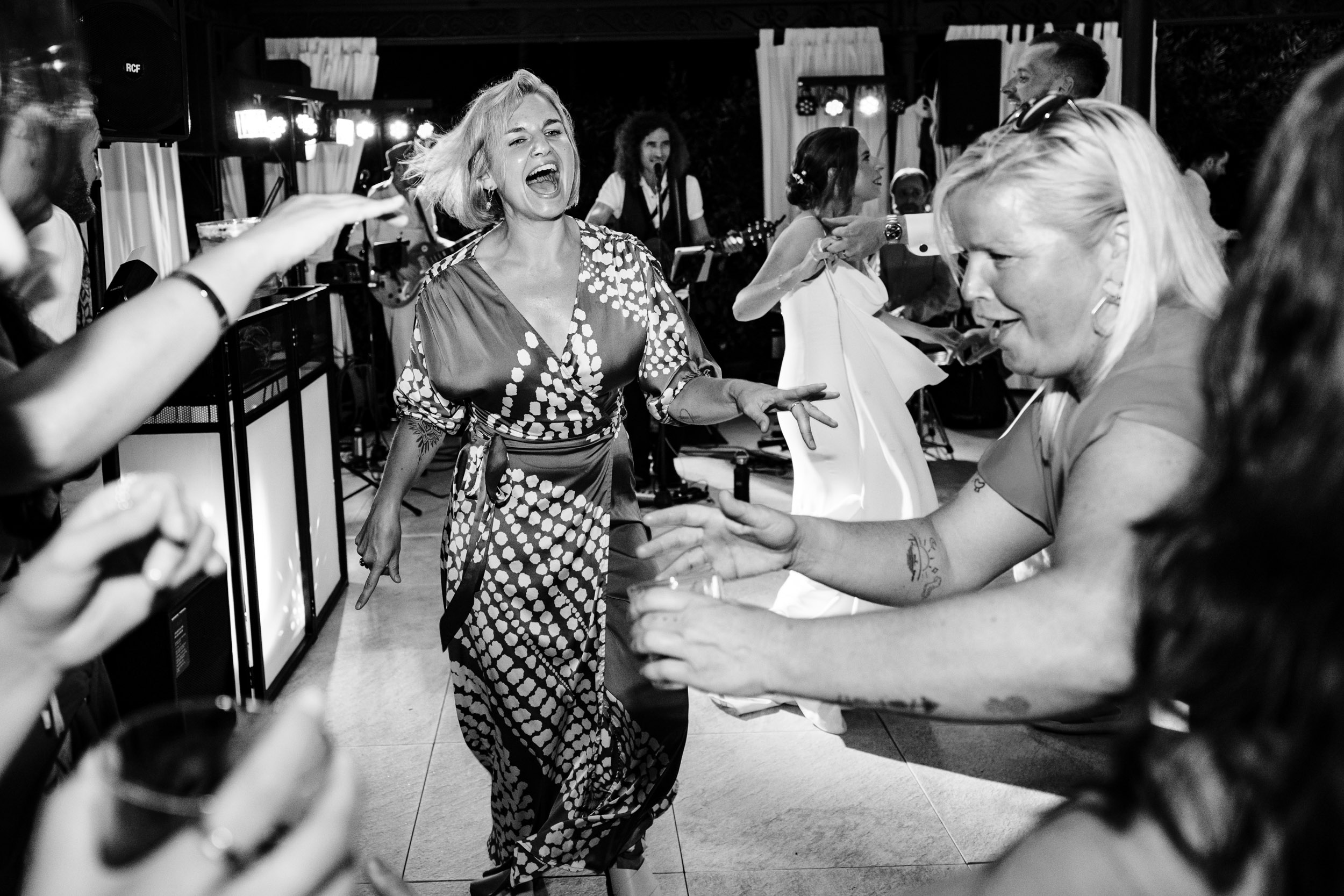 Wedding guests dancing energetically on the dancefloor at the evening reception.