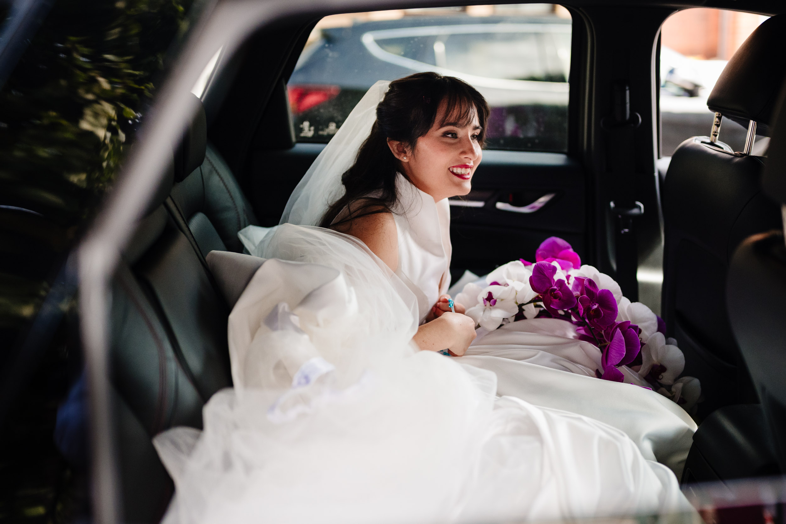 Sylvia smiling as she steps into the wedding car after the ceremony.