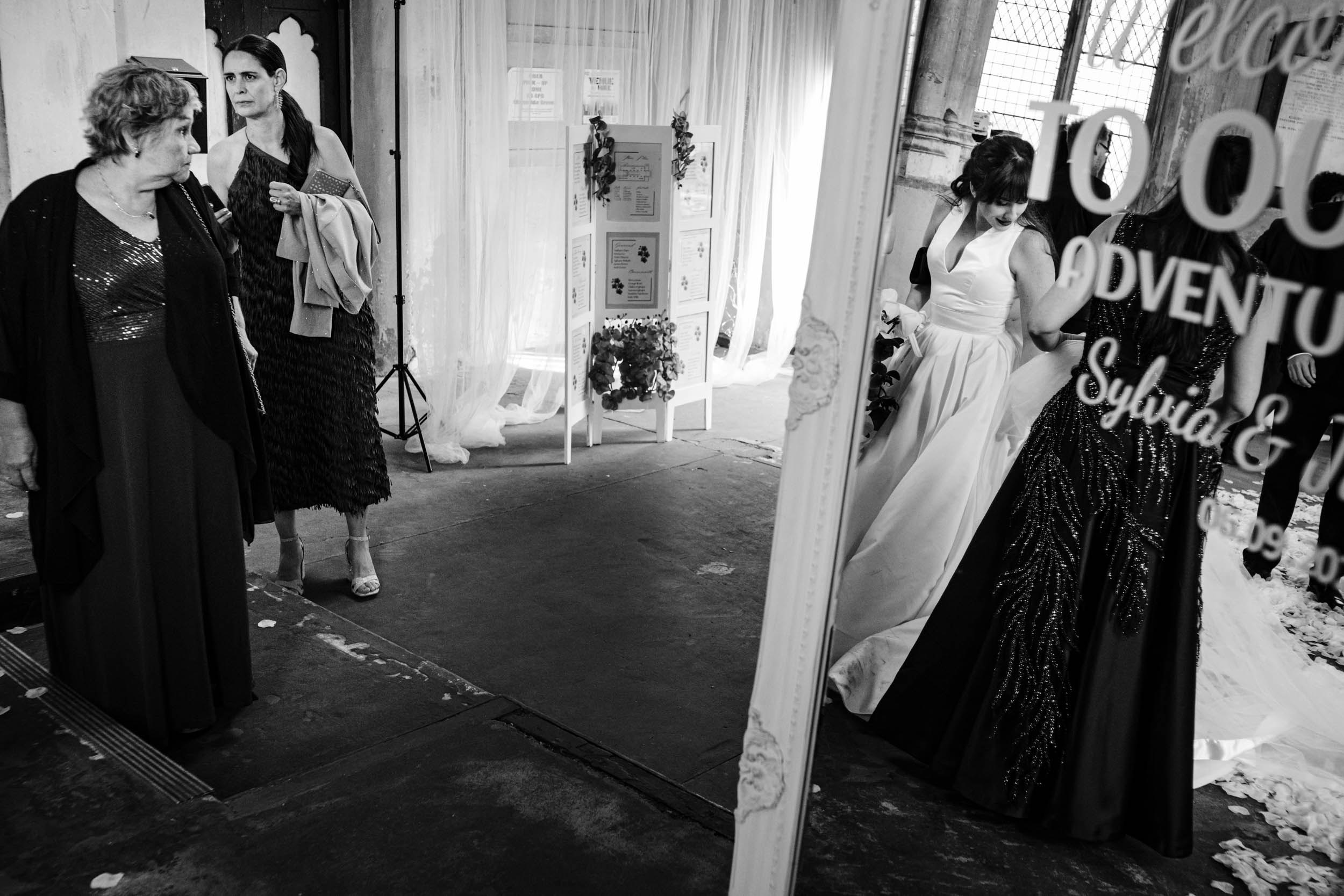 Mirror reflection showing Sylvia with her mum and nan among wedding guests at the reception.