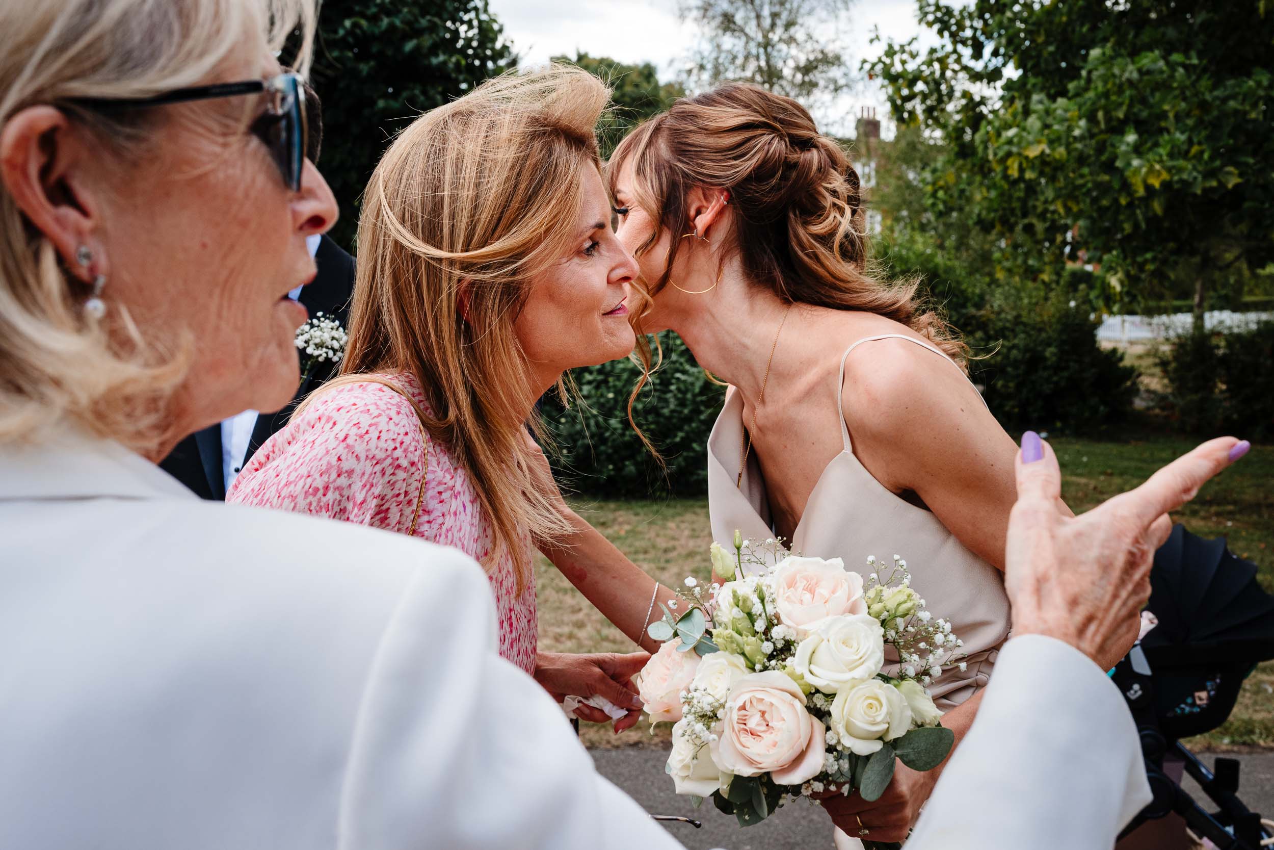 Wedding guests greeting each other with a kiss outside the church