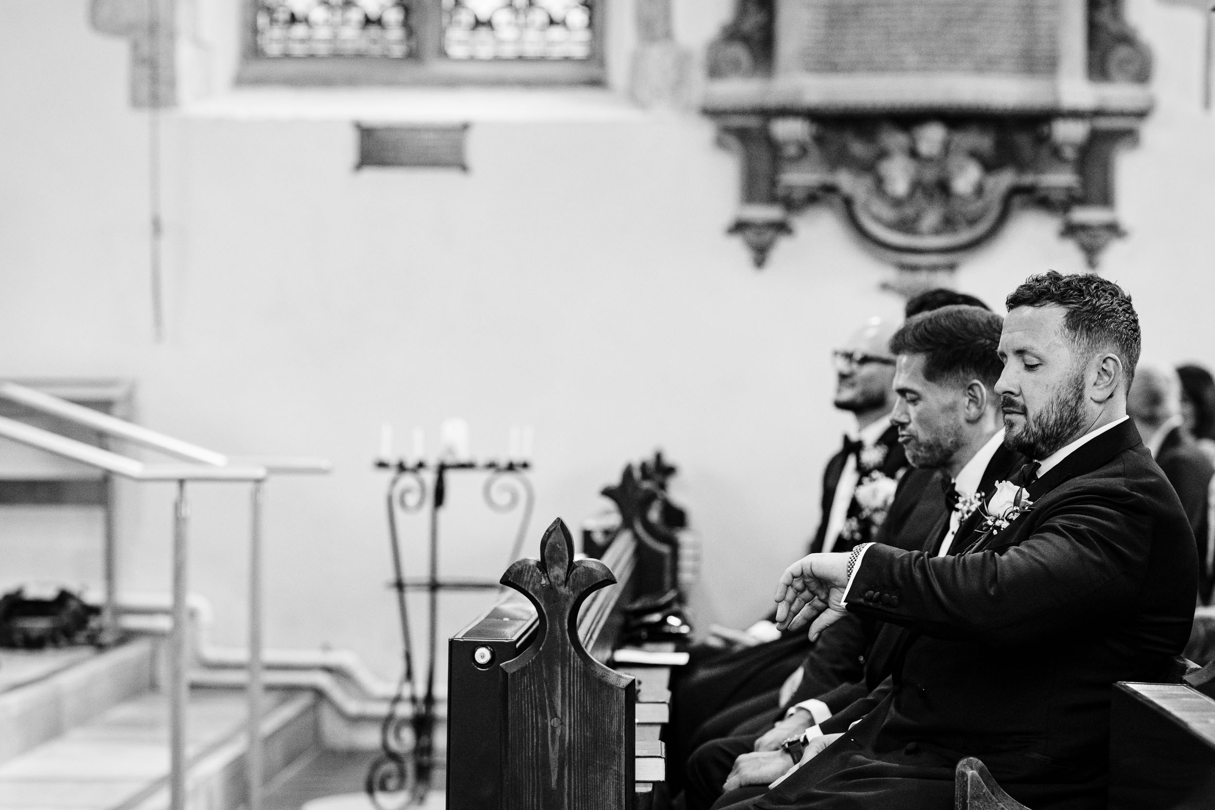 Groom checking his watch inside the church while waiting for the bride