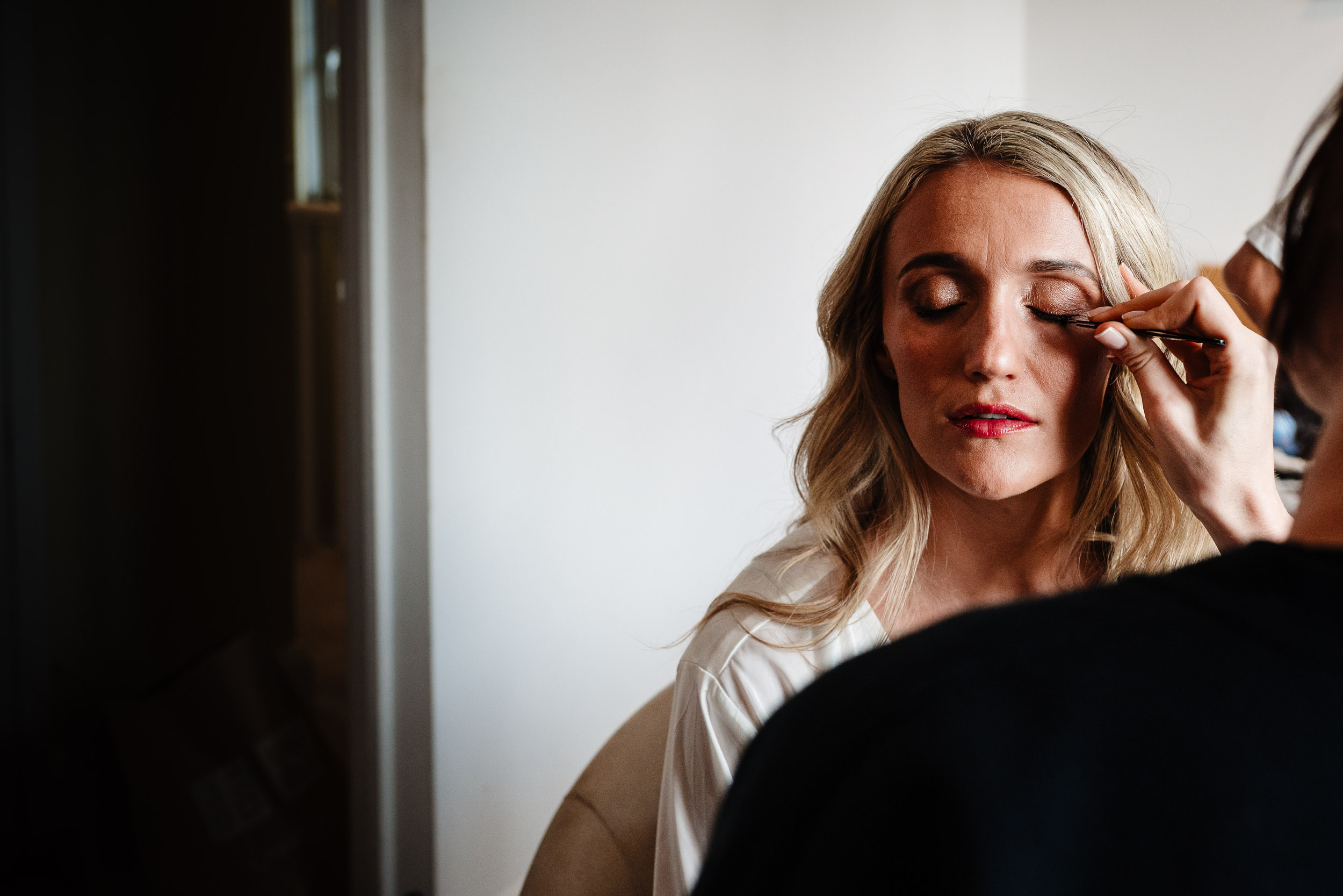 Bride having her makeup done before the ceremony