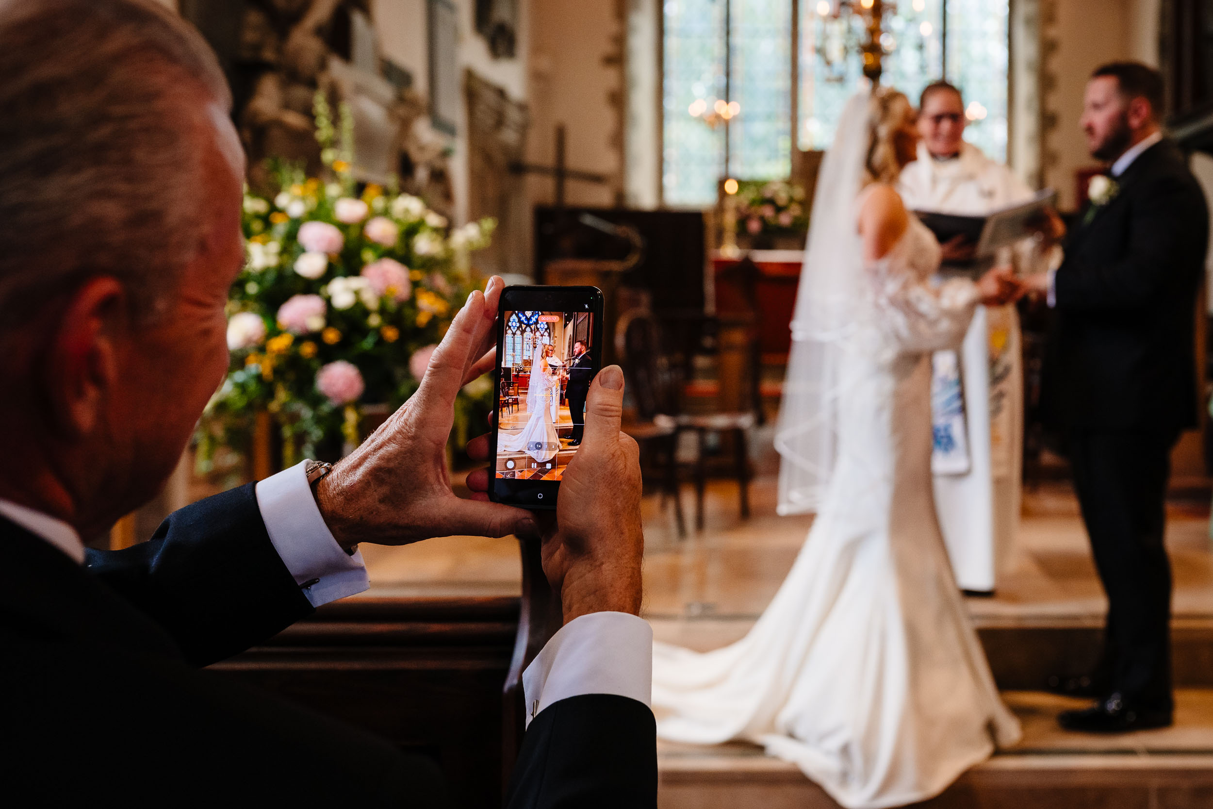 Father of the bride filming the ceremony on his phone