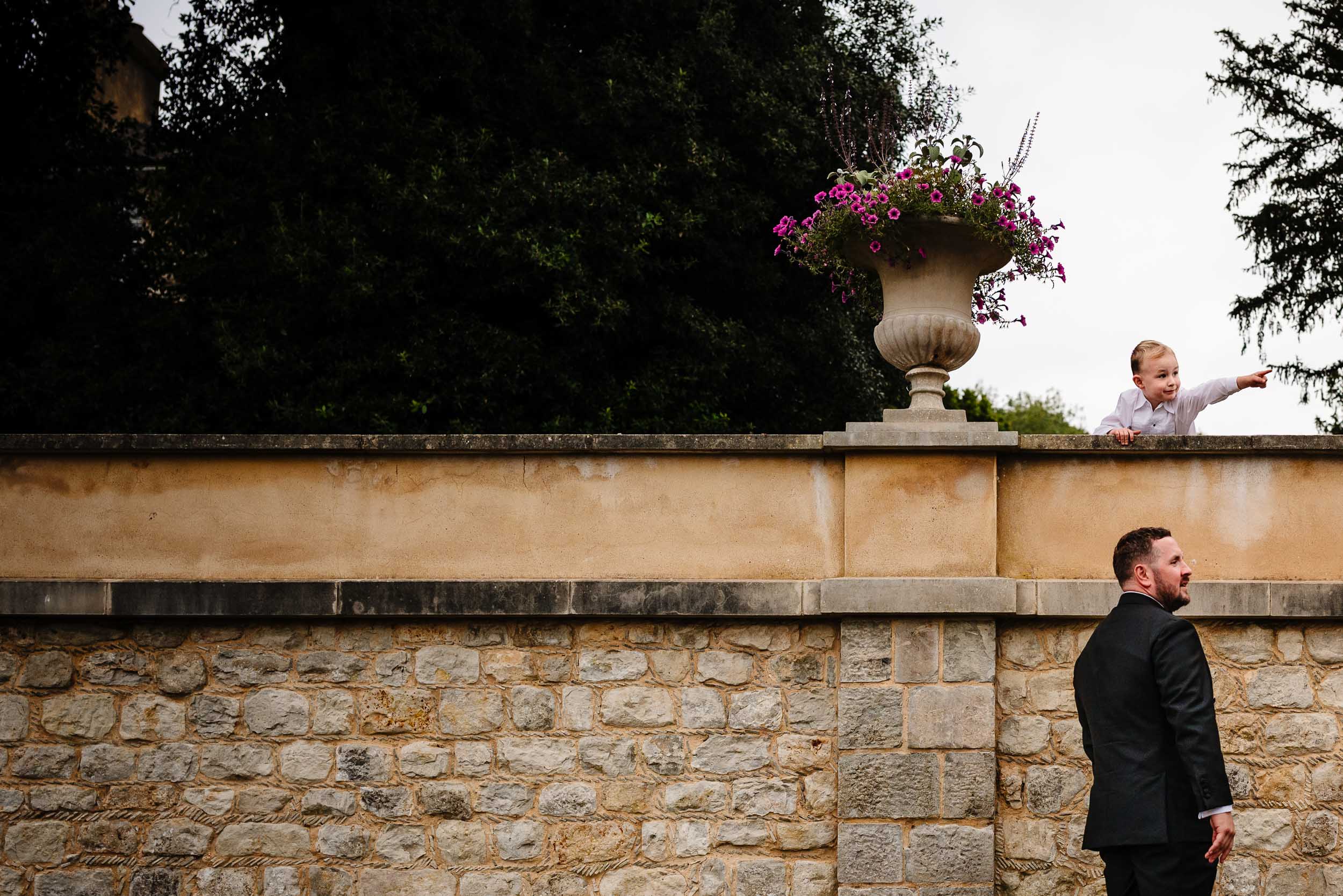 Groom and a child posing against a wall in a funny moment