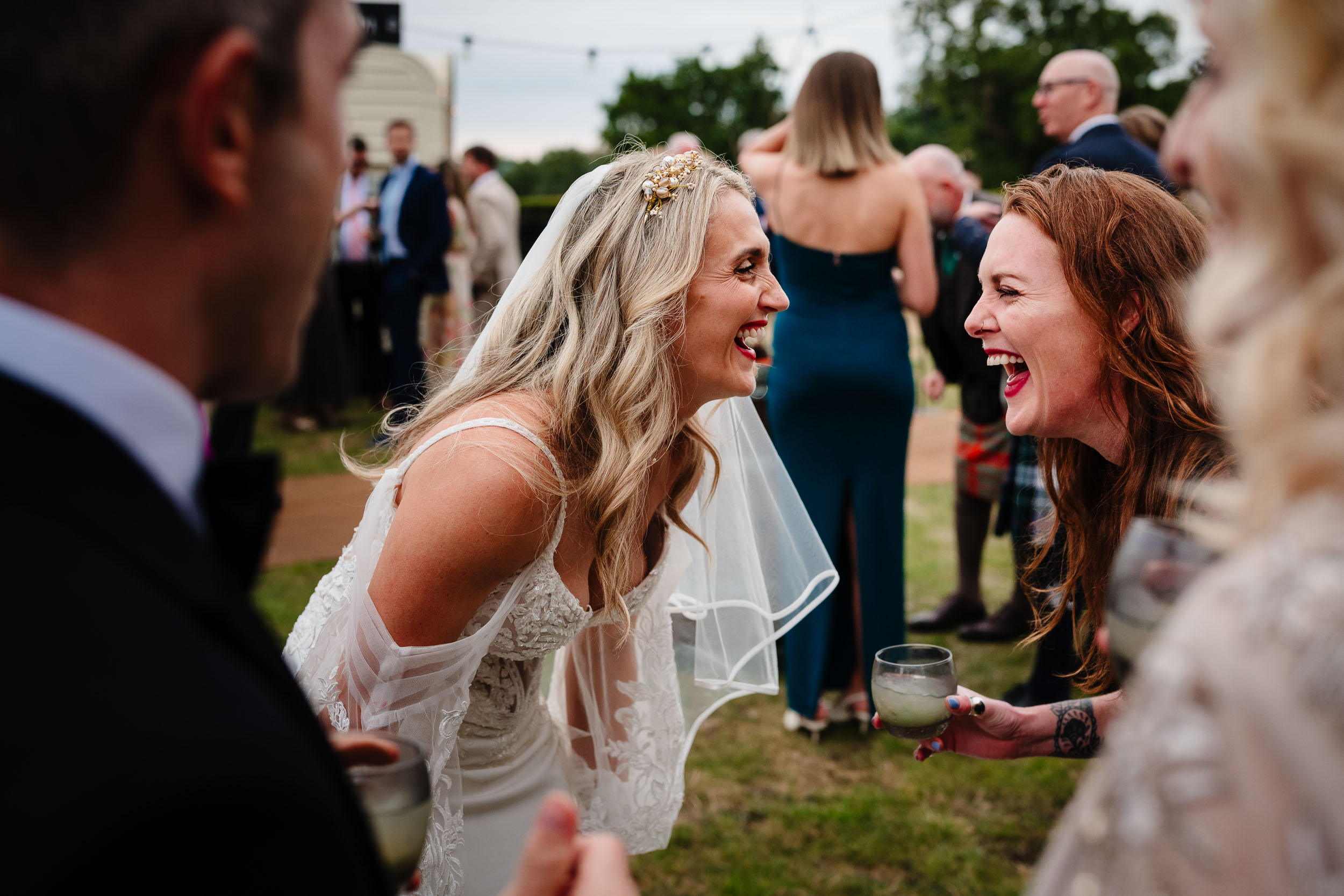 Bride and a guest sharing a big belly laugh together