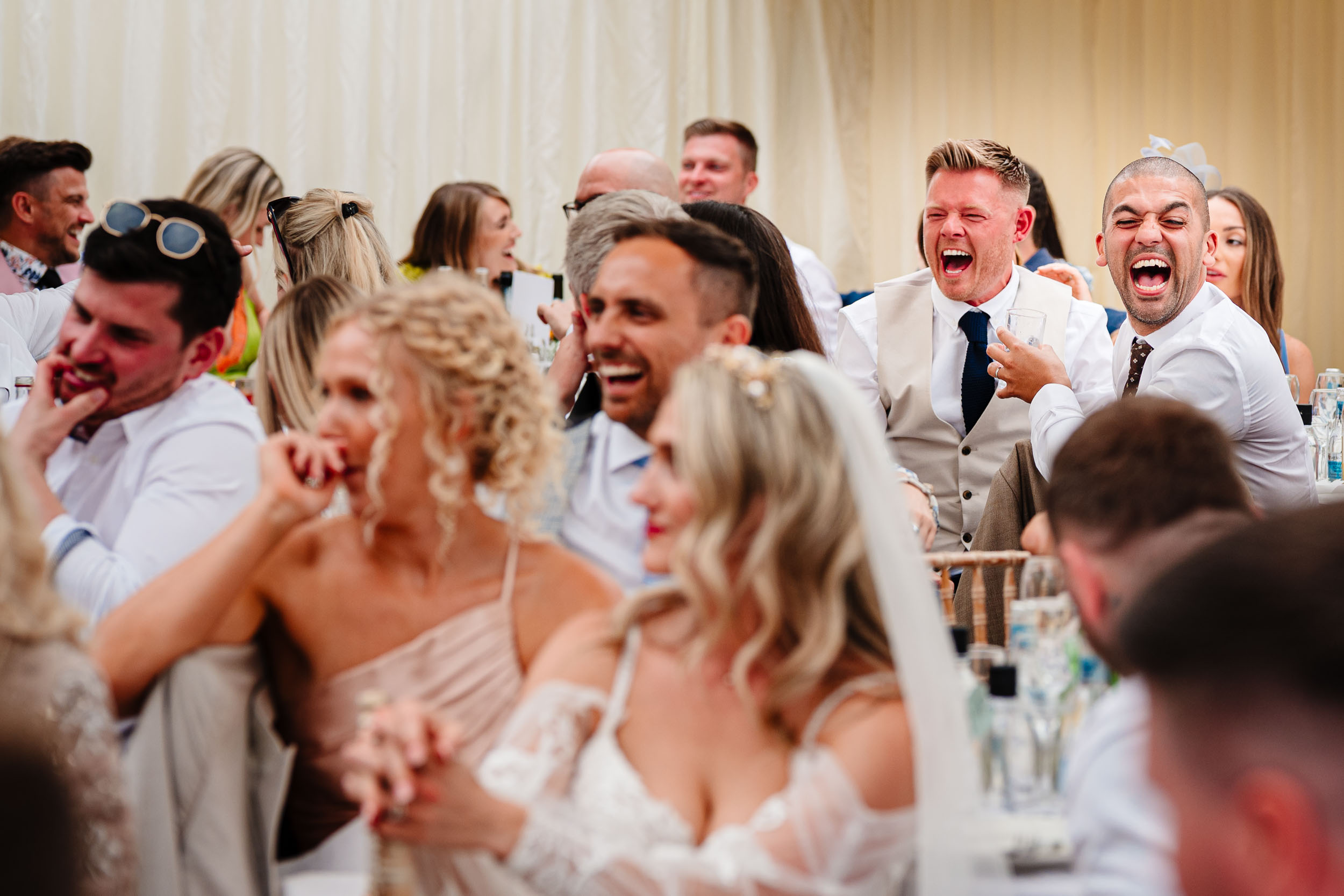 Wedding guests laughing during the speeches