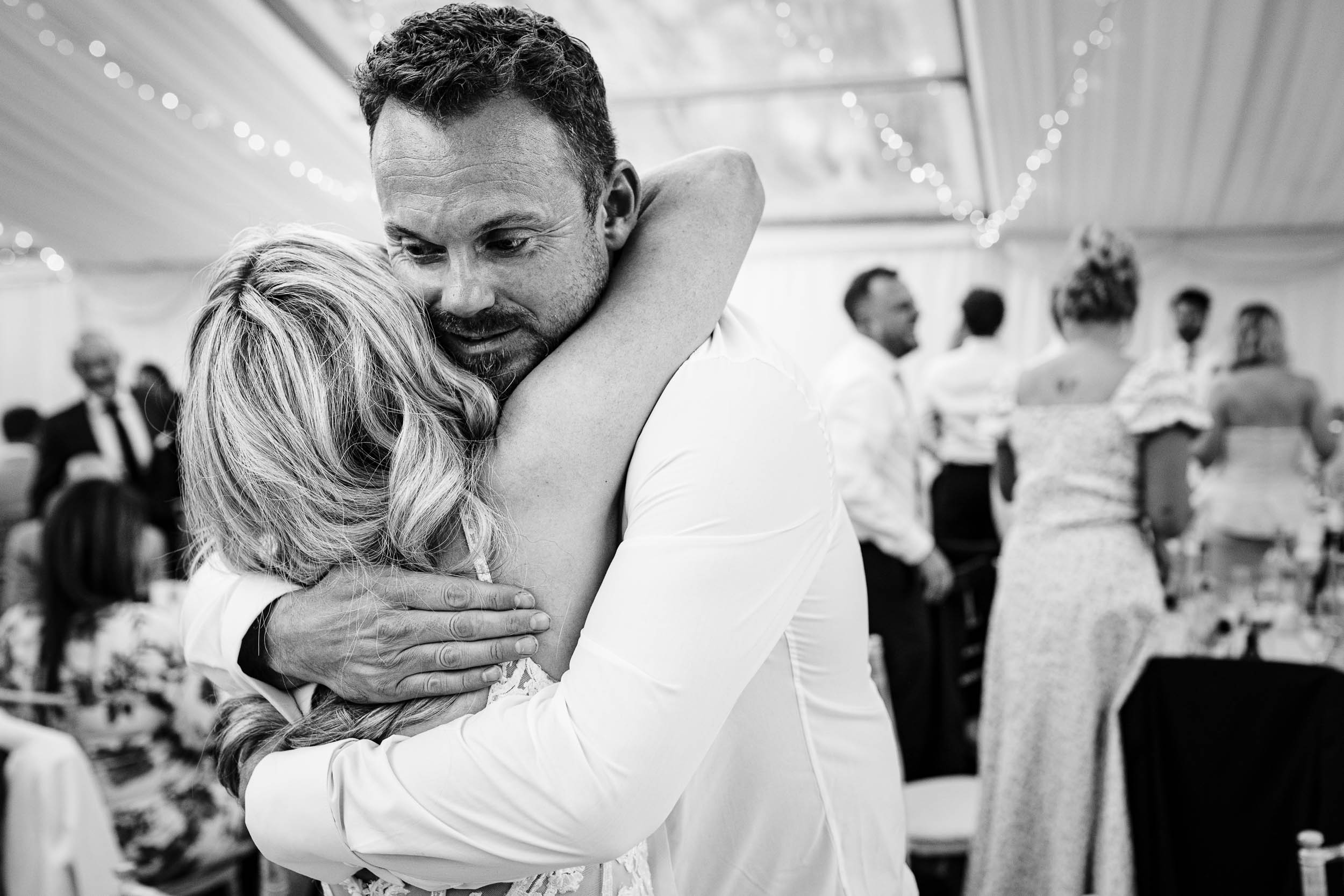 Bride hugging her brother in a warm embrace
