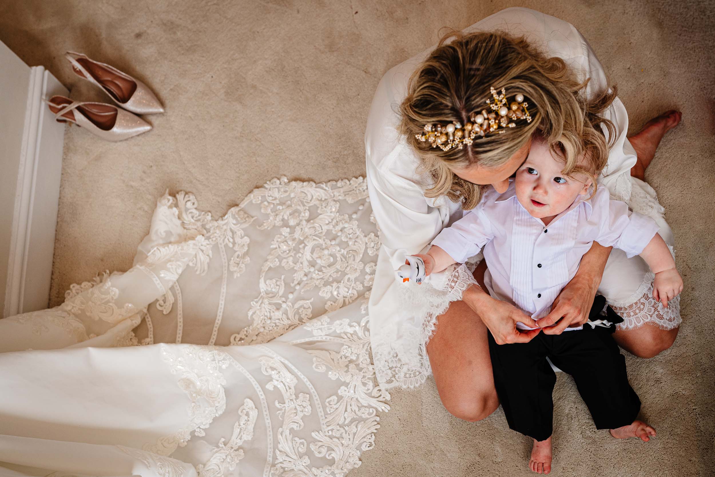 Bride helping her young son get ready on the wedding morning