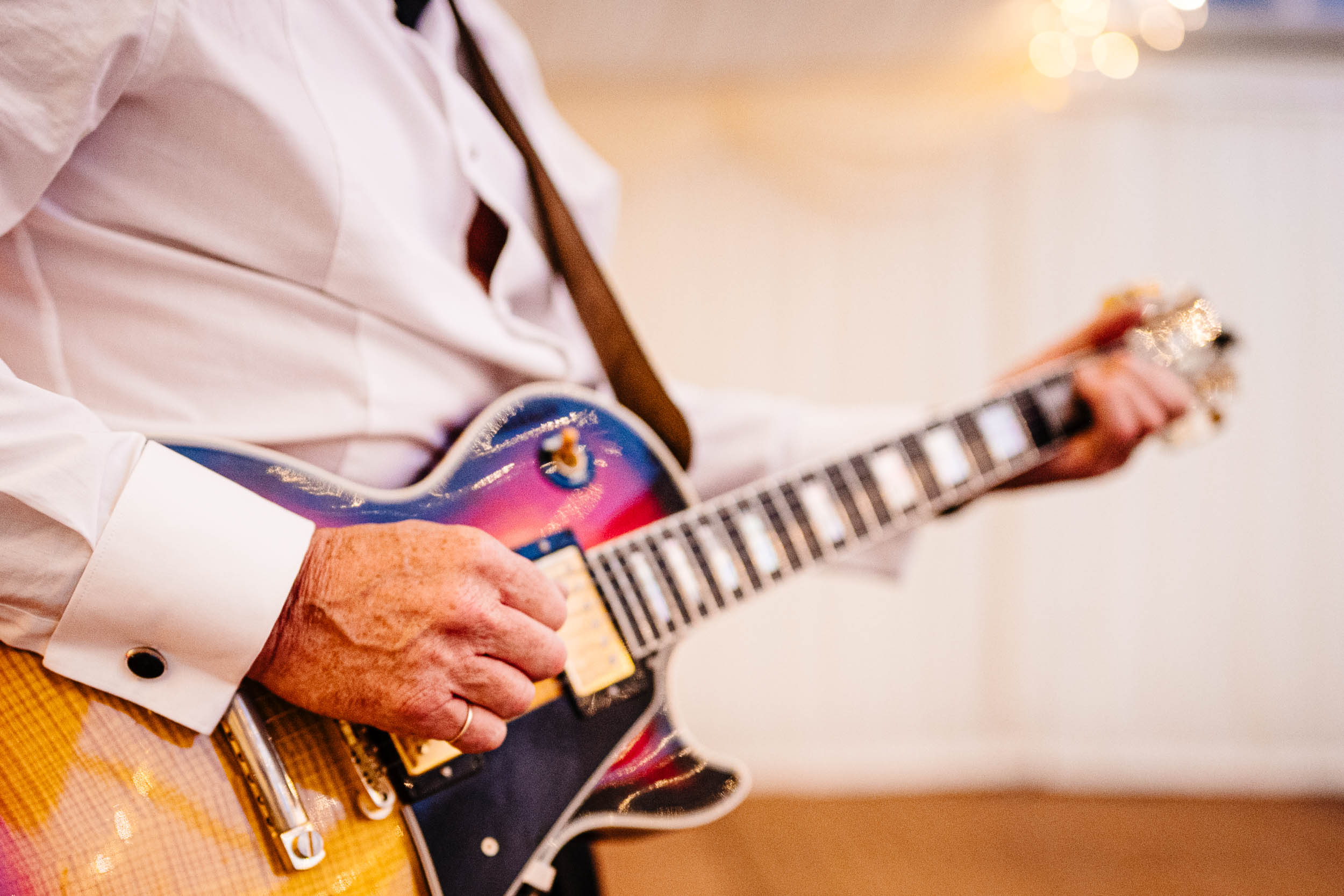 Close up of the bride’s dad playing the guitar