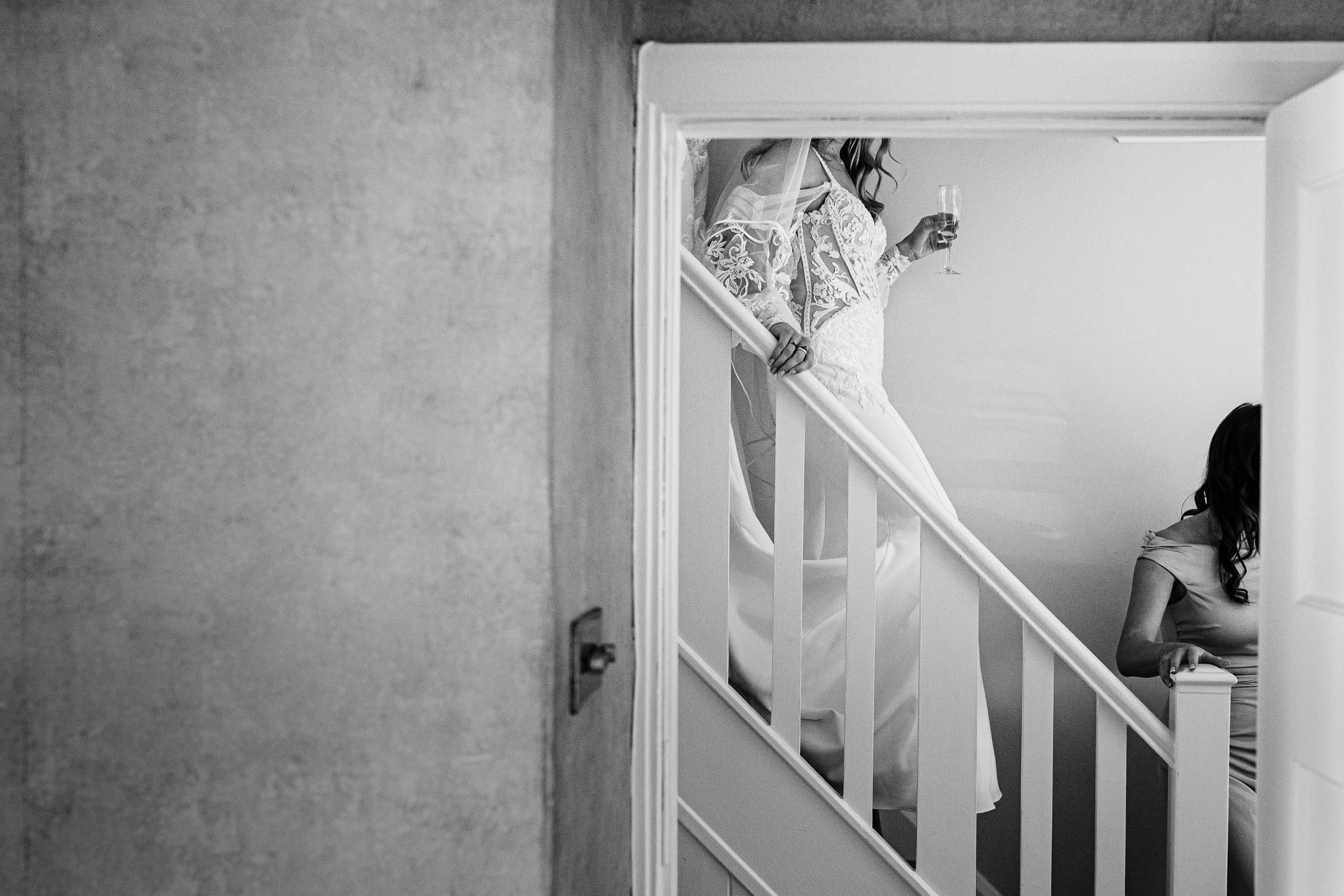 Bride walking down the stairs at home in her wedding dress