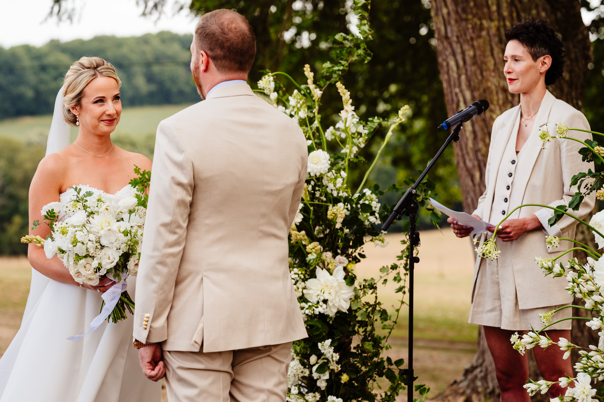 Bride and groom looking at each other during the ceremony as their friend officiates