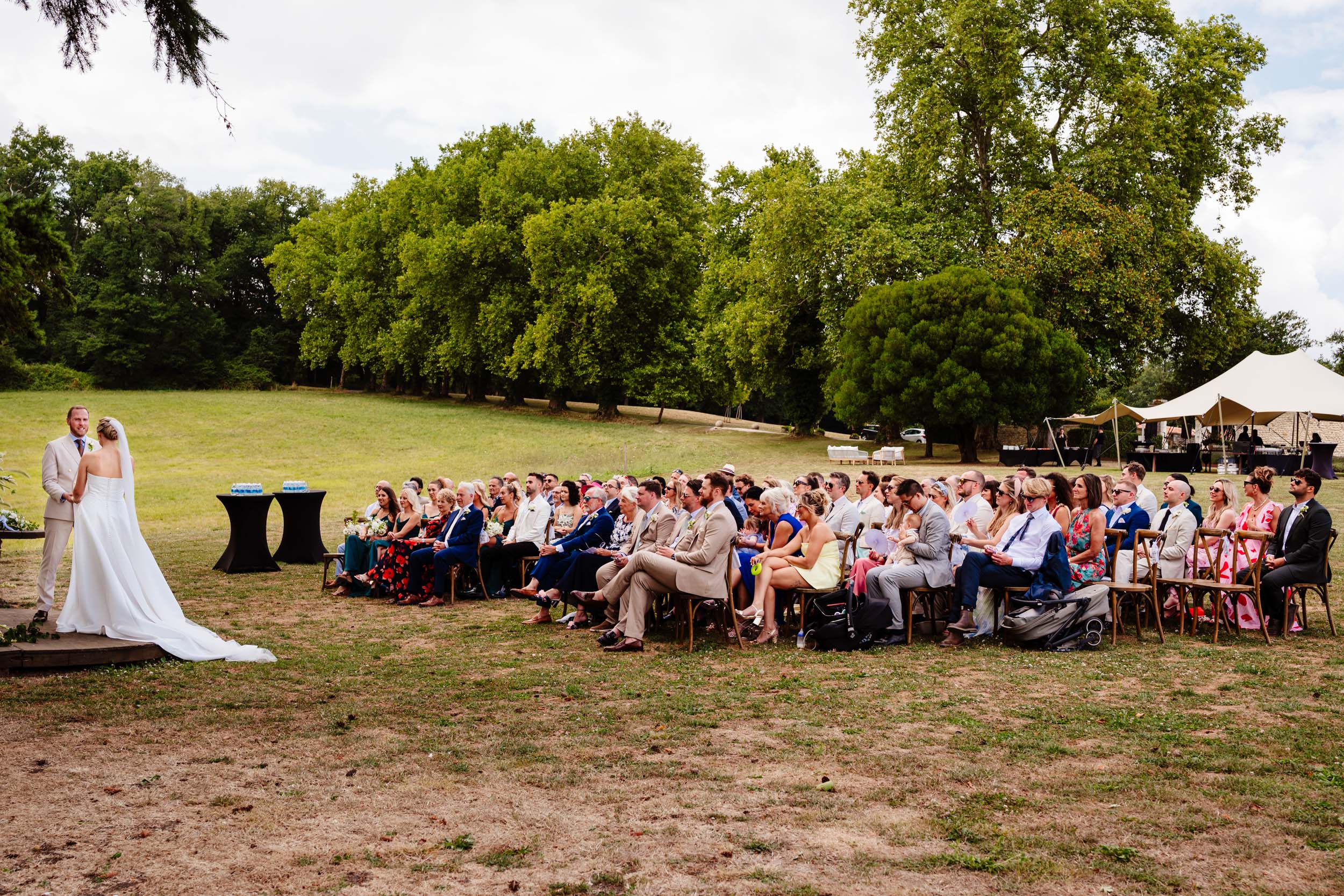 Wide view of the outdoor wedding ceremony with Chateau de Lerse in the background
