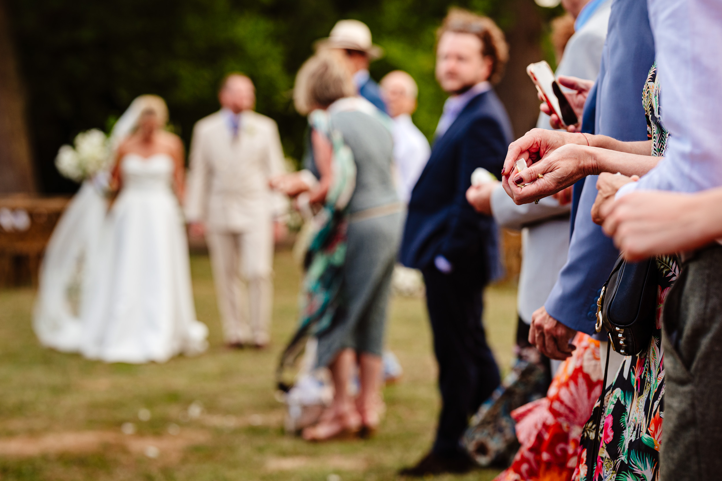 Close-up of a wedding guest holding confetti in their hands