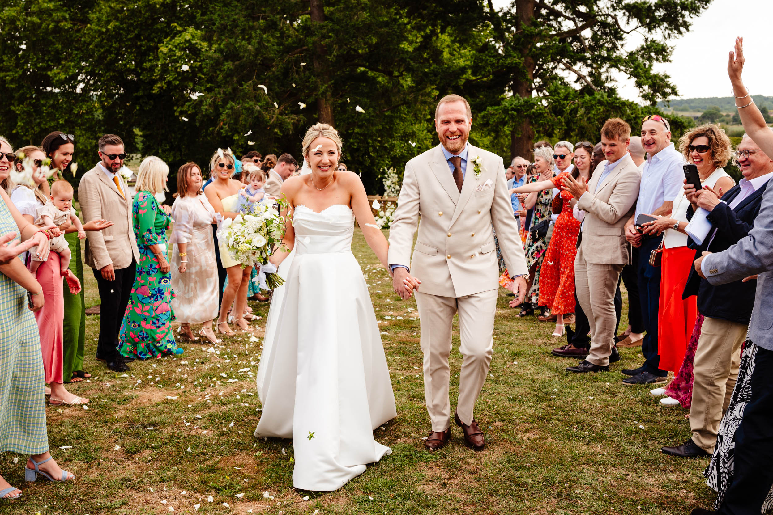 Bride and groom walking through colourful confetti during the post-ceremony celebrations