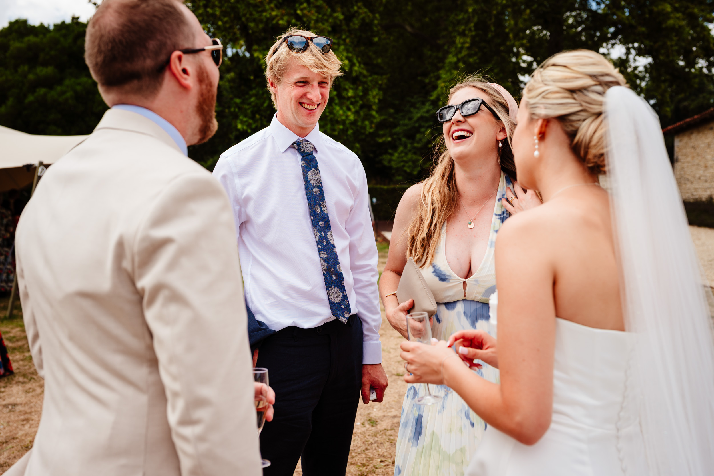 Bride and groom sharing a big belly laugh with wedding guests