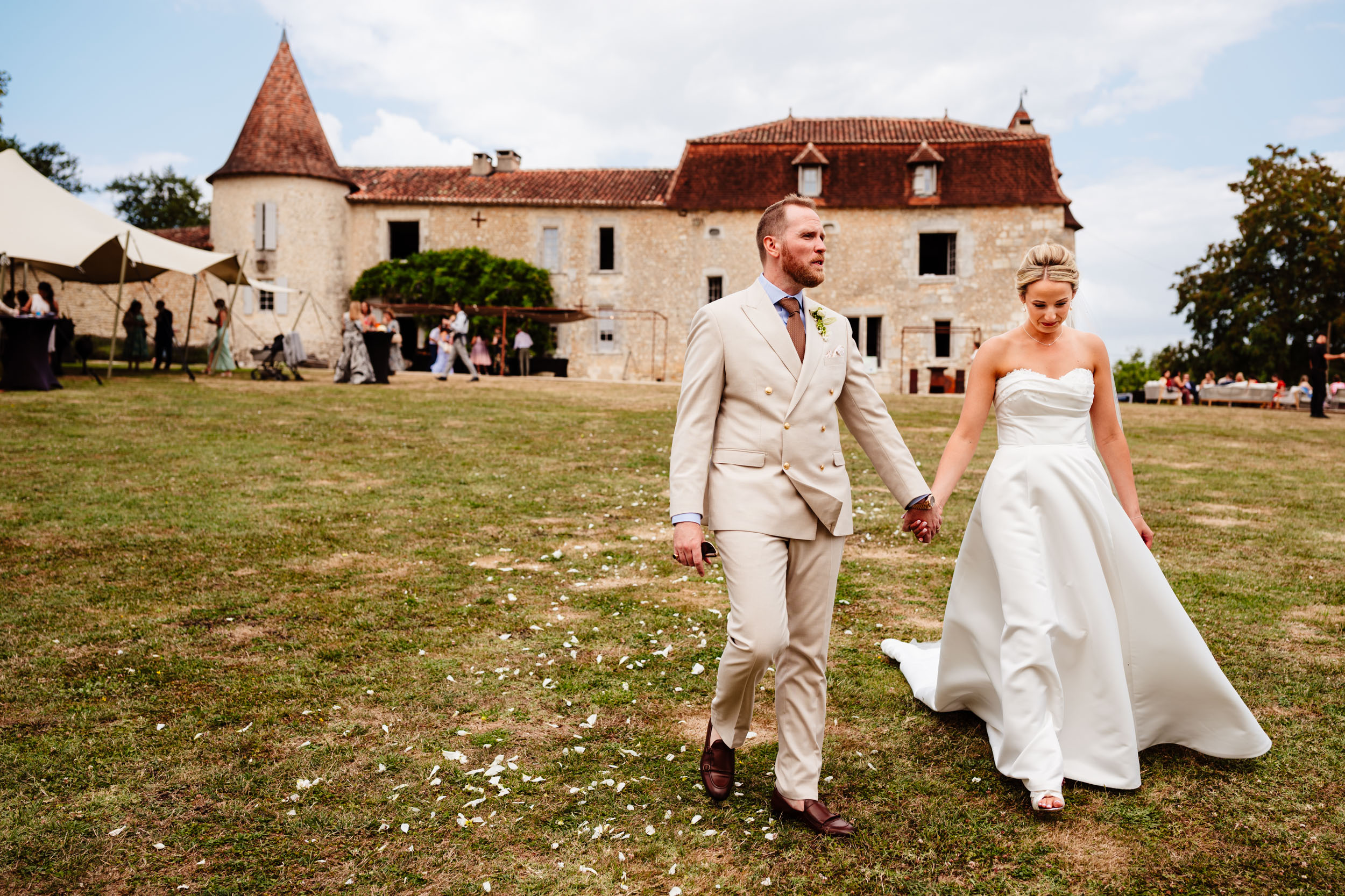 Bride and groom walking away together with Chateau de Lerse in the background