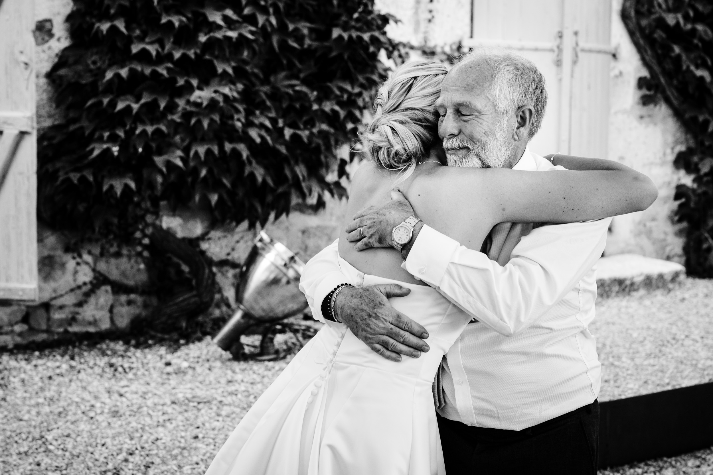 Bride sharing a heartfelt hug with the groom’s dad during the reception