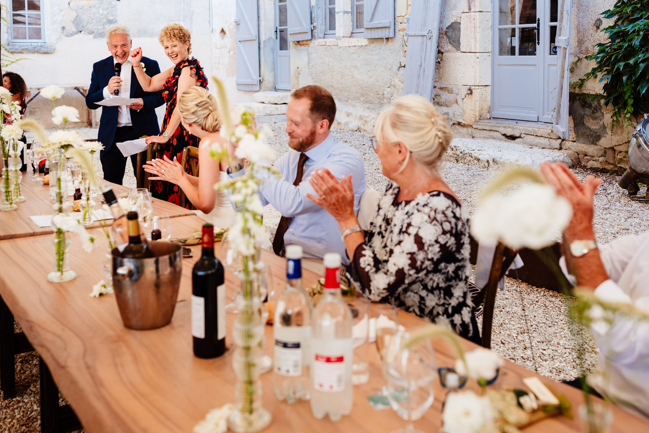 Guests laughing and clapping during speeches by the bride’s parents
