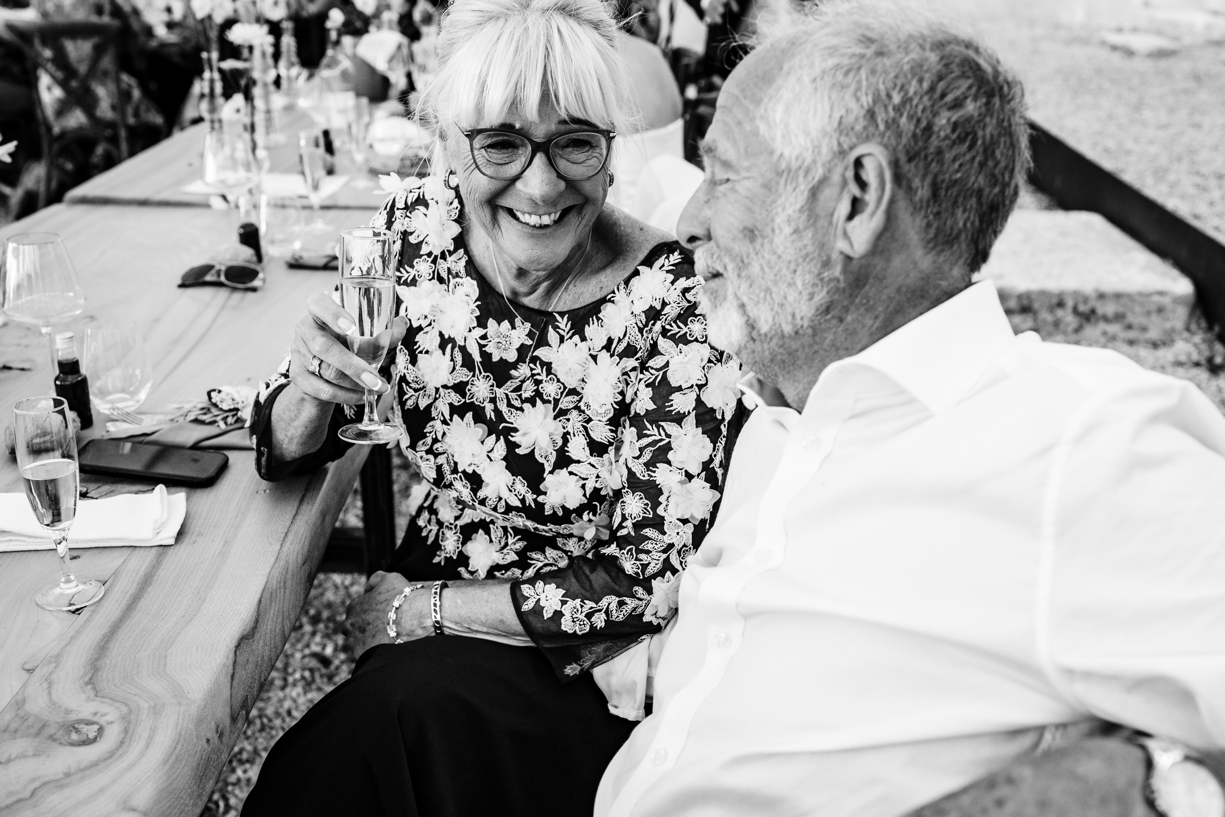Close-up of the groom’s parents sharing an emotional and cheerful moment during the speeches