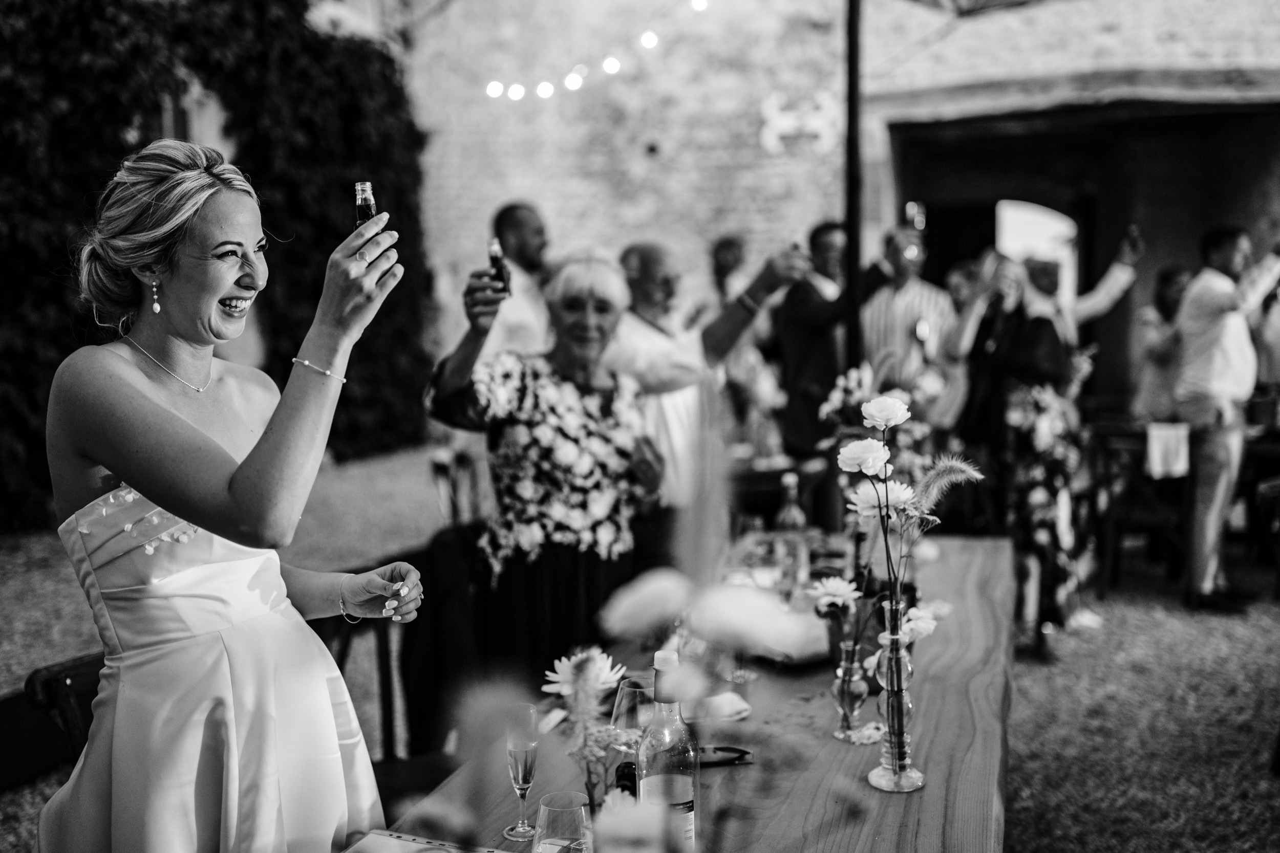 Wedding guests raising their glasses together for a toast