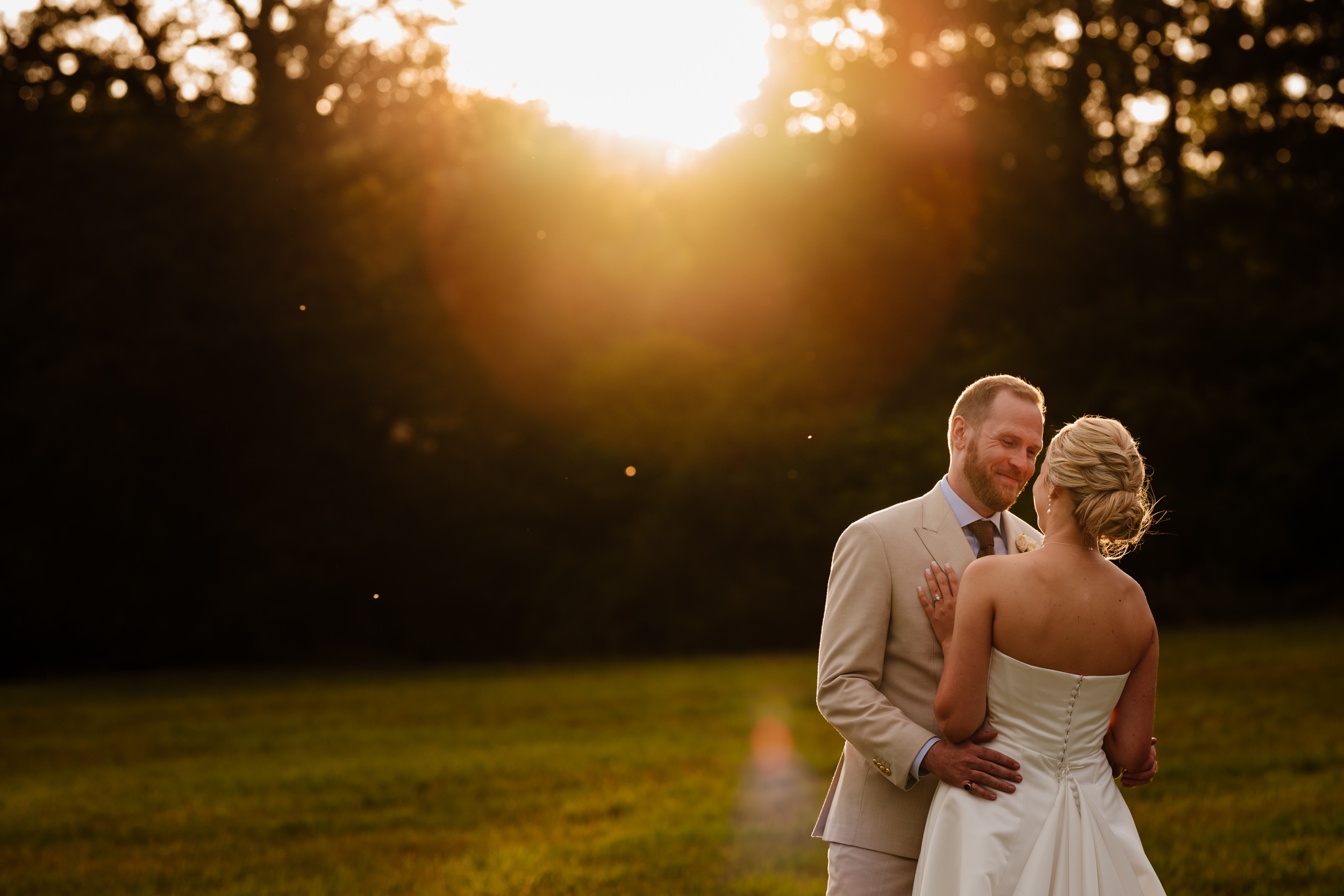 Bride and groom spending couple time together with the sun setting behind them