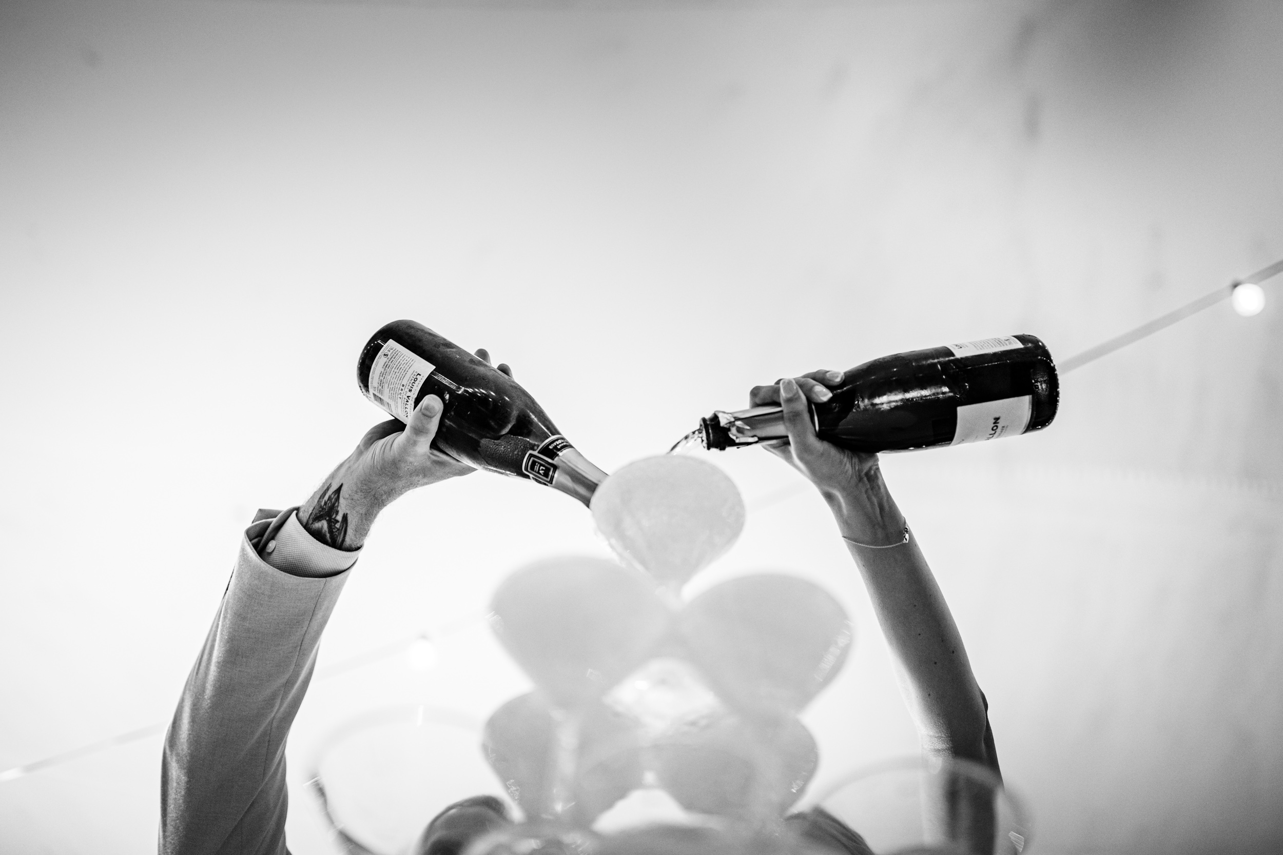 Bride and groom pouring champagne into a champagne tower