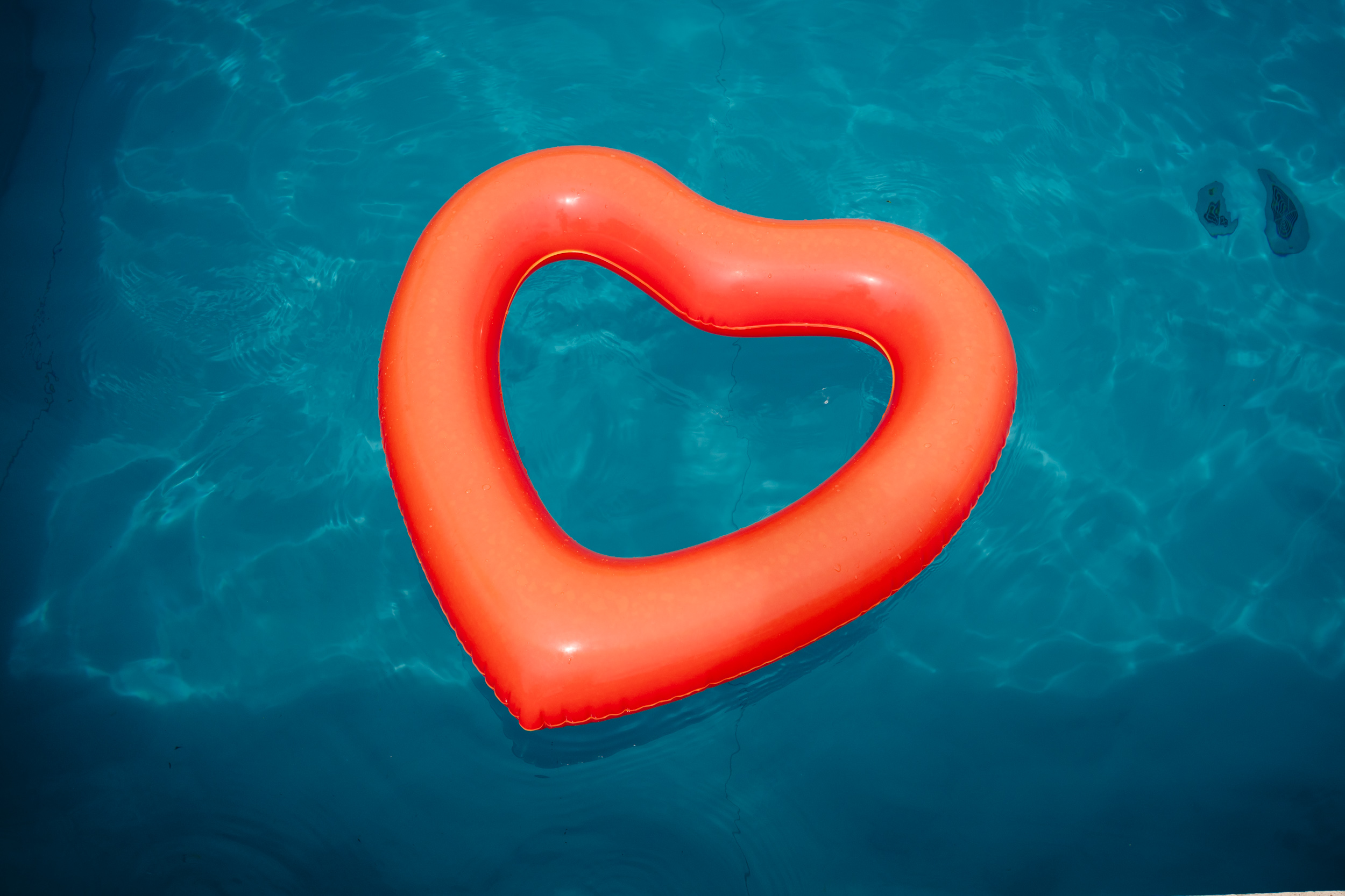Red heart floating in the swimming pool during the wedding pool party