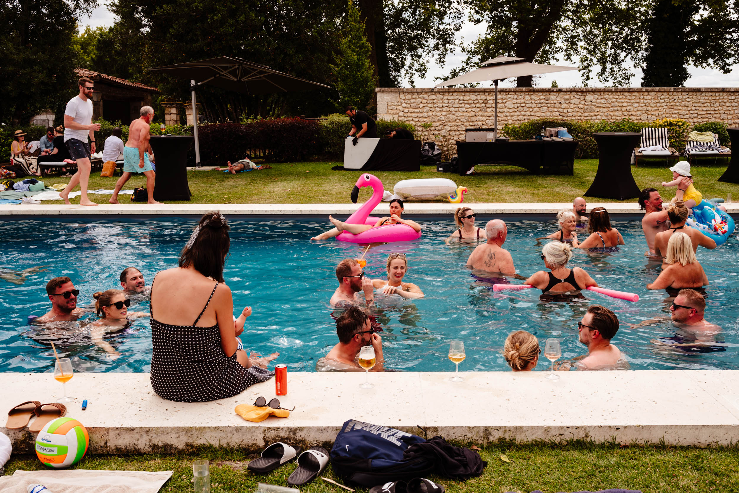 Busy scene of wedding guests enjoying themselves together in the swimming pool